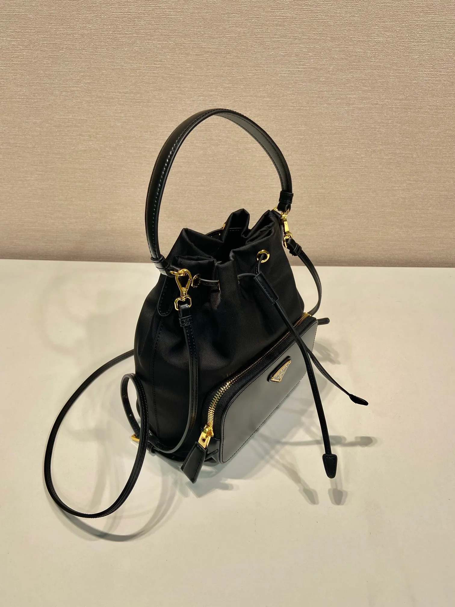 💰920🎉New bucket🎉1BH038 glossy/nylon fabric🎉🎉This casual and versatile bucket bag presents soft and smooth lines, highlighting modern style. Equipped with detachable handles and shoulder straps, it can be carried by hand or worn cross-body. It combines practical and innovative re-Nylon fabric (Re-Nylon), exquisite glossy leather details, and metal hardware. Featuring exterior zip pocket with enameled metal triangle logo. Another popular style that will never go out of style🎉🎉Babies; hurry up and get it🎉🎉 Length 17.5x Height 22.5x12cm