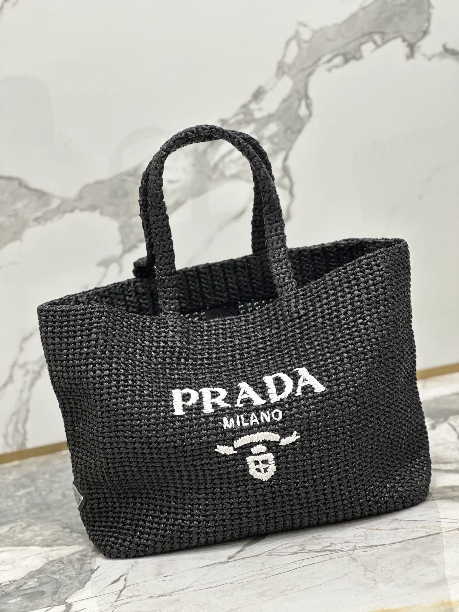 💰1900🌟Woven Tote Bag (Large Size) This tote bag is made of lightweight natural raffia fiber that is full of summer style. The soft deconstructed design gives the bag a unique modern charm. The iconic Prada lettering logo embroidery on the front subtly embellishes the silhouette. The striped pattern adds a contrasting element. So summery! Very versatile for everyday use. Size: length 40cm×height 34×width 15cm Style number: 1BG392