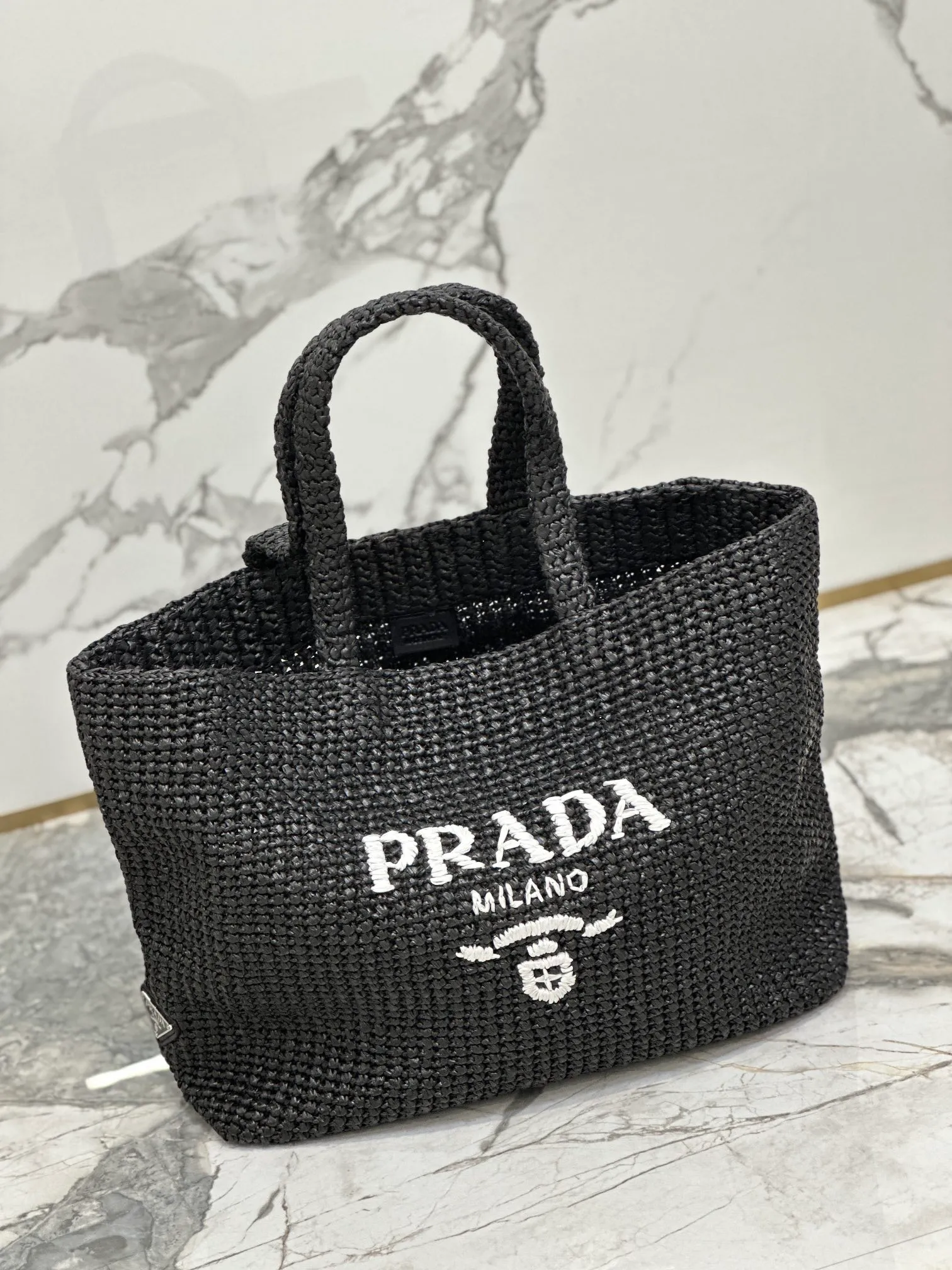 💰1900🌟Woven Tote Bag (Large Size) This tote bag is made of lightweight natural raffia fiber that is full of summer style. The soft deconstructed design gives the bag a unique modern charm. The iconic Prada lettering logo embroidery on the front subtly embellishes the silhouette. The striped pattern adds a contrasting element. So summery! Very versatile for everyday use. Size: length 40cm×height 34×width 15cm Style number: 1BG392