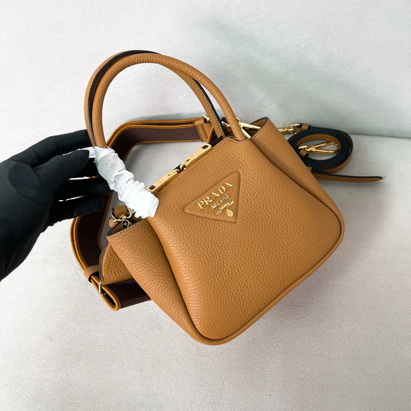 💰1760 ✨New product debut✨2025 new mini pebbled handbag/shoulder bag 1BA362 is made of soft textured pebbled calfskin. The bag has a rounded and soft silhouette. It is equipped with double handles and is decorated with a gold metal logo. Multifunctional detachable embroidered shoulder strap and leather shoulder strap. Elegant and outstanding style. Can be carried by hand, shoulder or crossbody. A handbag that perfectly blends classic heritage with contemporary trends. A must-have for fairies. Size 19.5*18*9cm