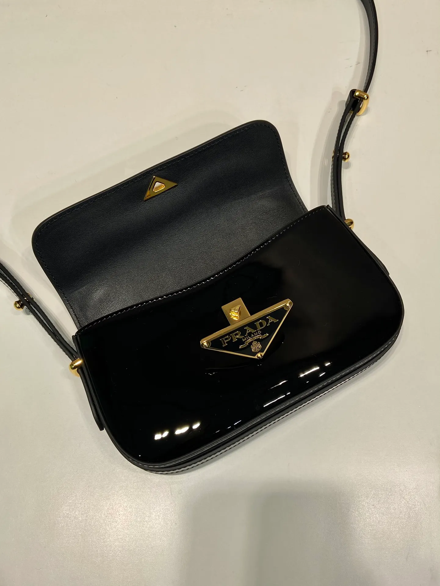 💰1460🎉New style🎉1BD339 patent leather🎉🎉 This shoulder bag demonstrates a simple design concept through its smooth lines and compact shape. It is made of patent calfskin outer/sheepskin inner fabric. It is equipped with an adjustable shoulder strap that can be carried on one shoulder/crossbody, with a maximum length of 110cm. The front lock buckle is embellished with the iconic triangle logo. Wear a bold upper body, beauties. Get it now. Length 20.5x Height 10.5x Bottom 4cm👏👏👏🎉🎉🎉