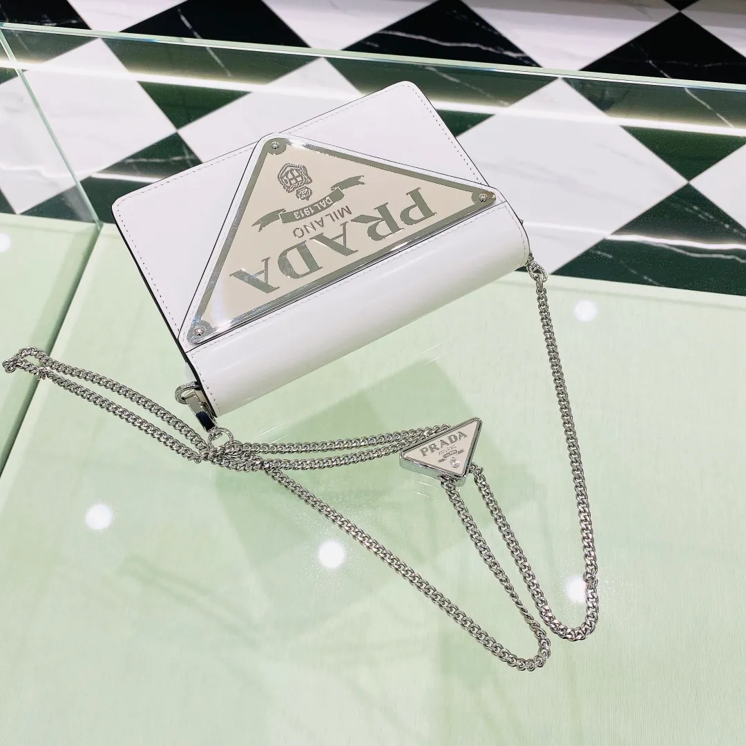 💰1320✨ New product debut✨🌟New inverted triangle decorated glossy cowhide flip shoulder bag 1BH189 Novel and interesting inverted triangle metal chain with fashionable glossy cowhide. The simple and elegant outline design and flip opening and closing give it a simple and fashionable style. It is simply great👏... The new favorite of fashion trendsetters. The perfect details are comparable to those of brick cabinets Super 5🌟 Size:17*9.5*3.5cm white