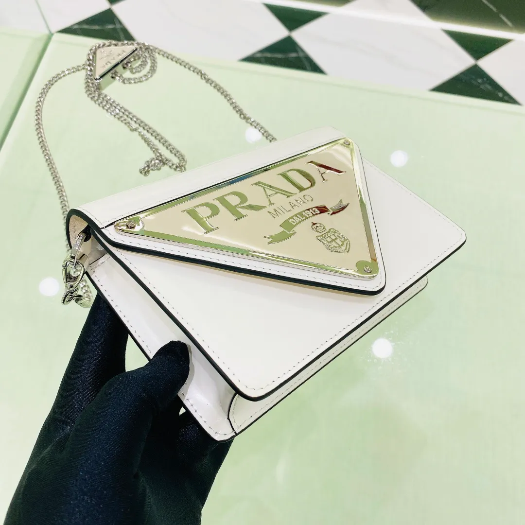 💰1320✨ New product debut✨🌟New inverted triangle decorated glossy cowhide flip shoulder bag 1BH189 Novel and interesting inverted triangle metal chain with fashionable glossy cowhide. The simple and elegant outline design and flip opening and closing give it a simple and fashionable style. It is simply great👏... The new favorite of fashion trendsetters. The perfect details are comparable to those of brick cabinets Super 5🌟 Size:17*9.5*3.5cm white