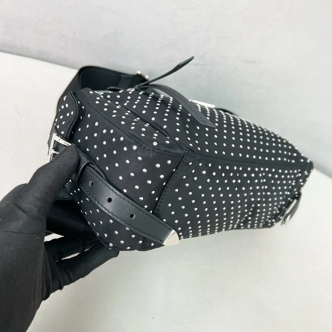 💰1320✨New product debut✨2025 new rivet decoration series crossbody bag 1BC236 Imported recycled nylon fabric with rivet decoration Classic triangle logo The overall bag body is casual and not easy to deform Front zipper pocket ➕Double side pocket design meets various storage needs for daily travel Fashionable and casual, versatile, lightweight, easy to wear, easy to match, casual in different carrying methods and easy to put anywhere Just pick it up and instantly transform into a pretty lady🤩 Size: 26/17/9
