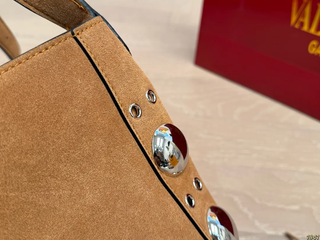 ¥330 with box Valentino tassel rivet handbag The tassel embellishment is super personalized! The V-shaped logo on the front is super classic and highly recognizable. The shoulder strap is adjustable, so it can be carried by hand or carried on the shoulder. It has a large capacity and can hold daily small items for commuting and traveling. The rivets and tassel design make the bag more layered, and it looks great with simple or retro styles. It is practical and fashionable, and can easily enhance the quality of your outfit! Size 29*30