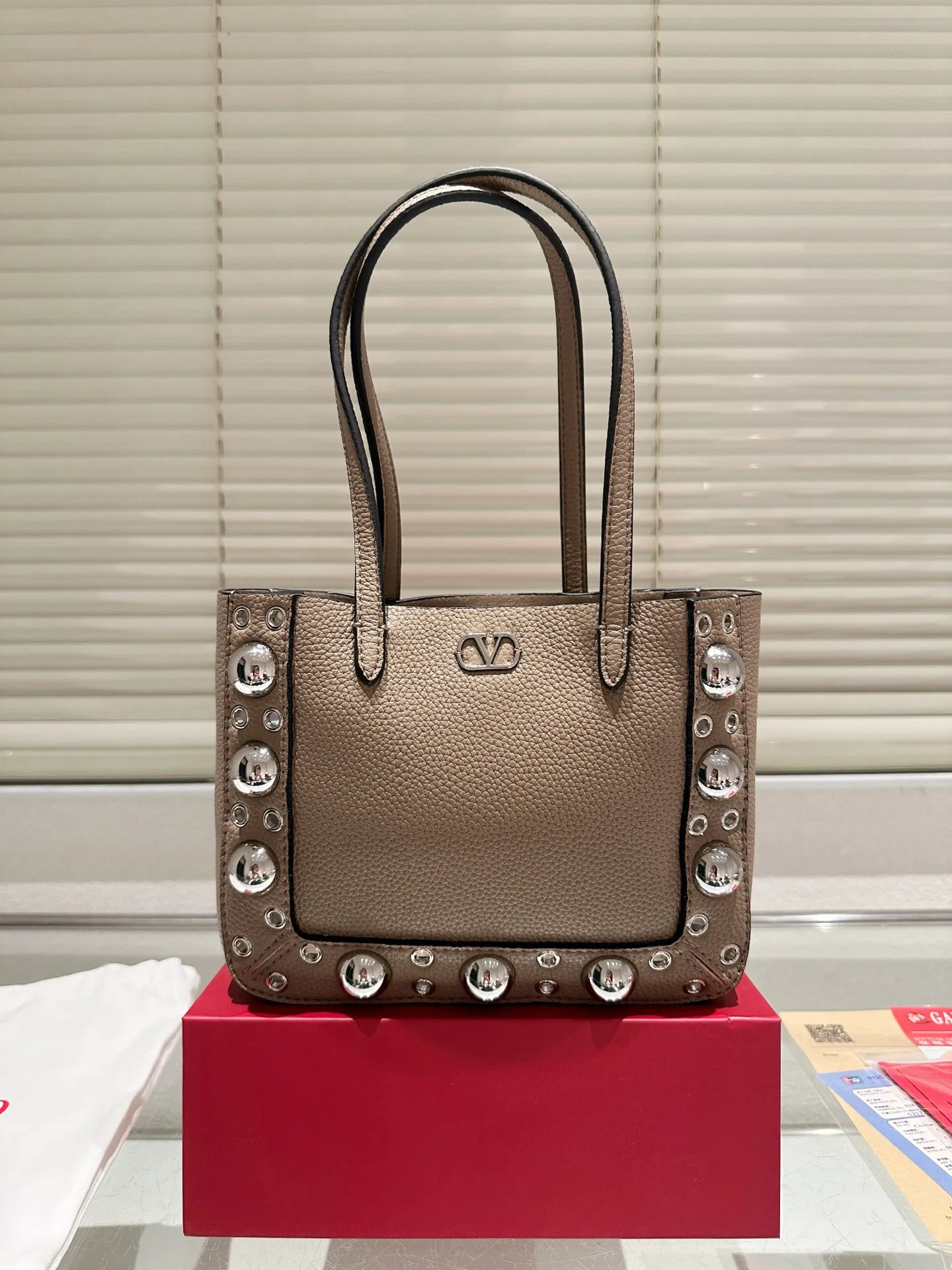 P360 comes with box, size 21*17 Valentino nellcote tote bag, suede body, decorated with ball rivets and hollow details, balancing retro and fashionable. It can be freely switched between hand-carrying and shoulder-carrying, and combined with a detachable carrying bag, it combines practicality and fun.