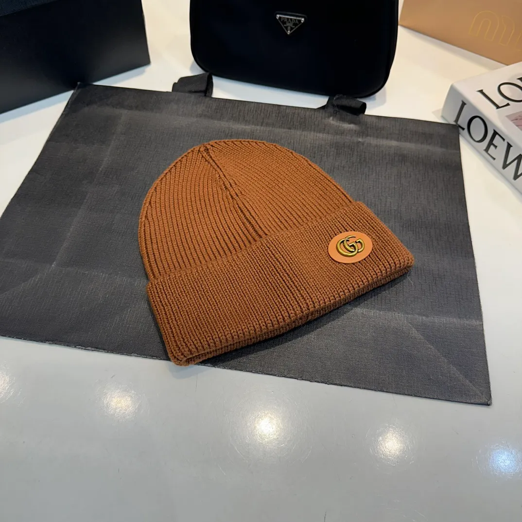 P56 GUCCI Autumn and Winter This series of soft accessories has elegant colors and cleverly incorporates collection elements. Crafted in camel, this hat is crafted from ribbed-knit wool and cashmere-blend. The oval Double G leather patch adds a subtle logo connotation to the entire design. Genuinely textured knit wool and cashmere blend Gold-tone hardware Oval Double G leather patch