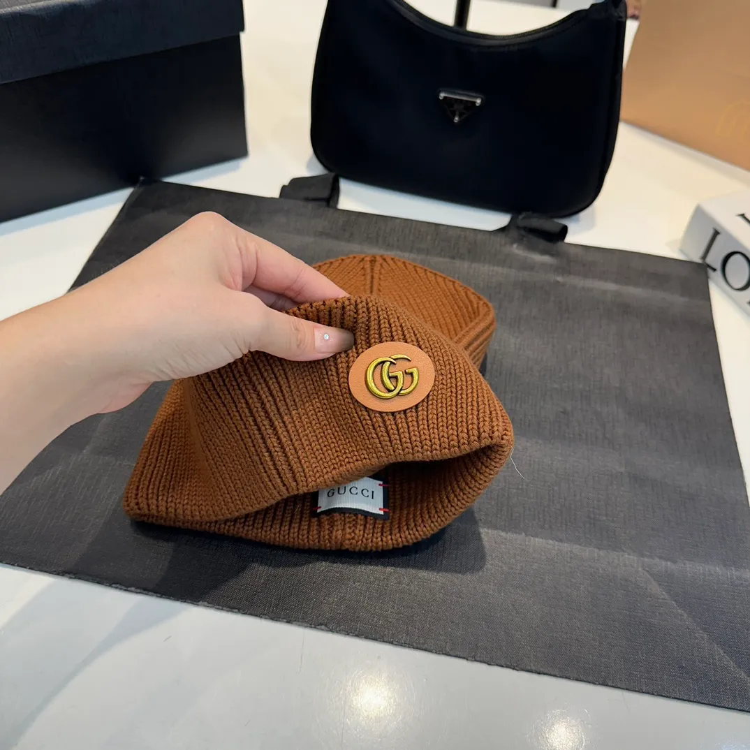 P56 GUCCI Autumn and Winter This series of soft accessories has elegant colors and cleverly incorporates collection elements. Crafted in camel, this hat is crafted from ribbed-knit wool and cashmere-blend. The oval Double G leather patch adds a subtle logo connotation to the entire design. Genuinely textured knit wool and cashmere blend Gold-tone hardware Oval Double G leather patch