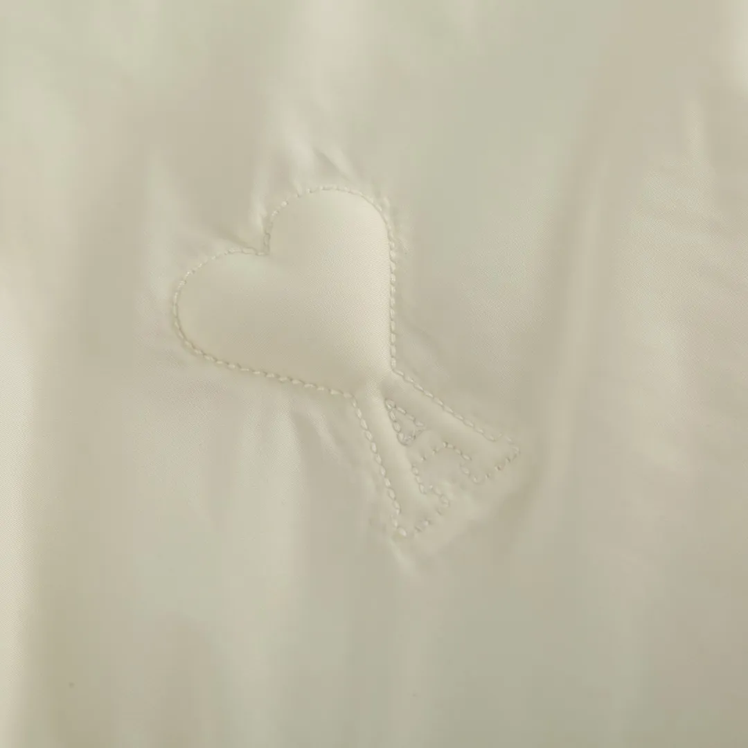 🅿️1000 Ami love padded embroidered down jacket (white) The fabric is made of taffeta fabric woven from 100% polyester fiber. It adopts warp and weft plain weave and is woven very tightly, making the surface of the fabric extremely smooth and flat, with a "skinny" and stiffness that is not easy to collapse. When rubbed or moved around, it will make a unique, crisp "rustling" sound. At the same time, it has a delicate plain texture and a soft, elegant silky luster. This kind of luster is not as dazzling as satin, but more restrained and advanced. The high-quality filling is made of 90 white duck down, with a weight of 160g, ensuring excellent thermal insulation performance. After strict screening and processing, the velvet is not easy to get drilled, ensuring durability. The lining is made of 100% nylon. The high-density and tight weaving process prevents tiny lint from emerging from the gaps in the fabric. The smooth surface improves the putting on and taking off experience, and the excellent wear and tear resistance ensures damage caused by frequent use, while the light and soft texture does not affect the overall weight. Tightly fasten the fabric and padding material to the frame of the embroidery machine. The embroidery machine uses sparse stitches along the padding layer's pattern to outline the filling area of ​​the pattern. Then it runs the overlay layer's pattern, using dense stitches to perfectly cover the foam padding layer to form a slightly raised love embroidery, which feels soft and full, enhancing recognition while maintaining a low profile. Size: S-M-L