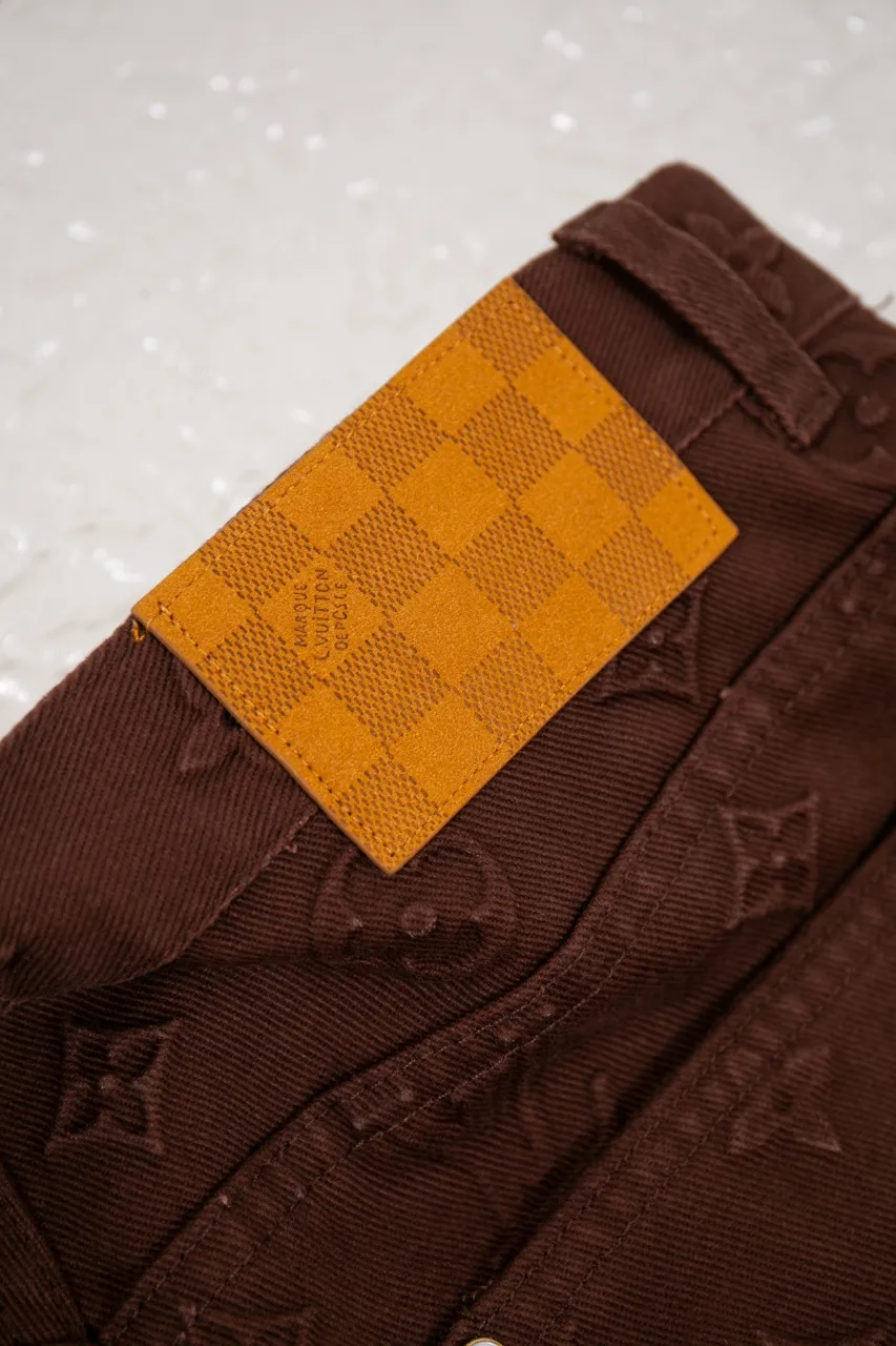 The new LV 25ss skateboard pants feature an all-over Monogram embossed pattern, cleverly integrated into the nubuck leather Damier label, pearlescent buttons and rivets, demonstrating Louis Vuitton’s exquisite craftsmanship. The elegant silhouette is dip-dyed in a calm hue that pairs well with the coordinating jacket-style shirt. Number of yards: 29.30.31.32.