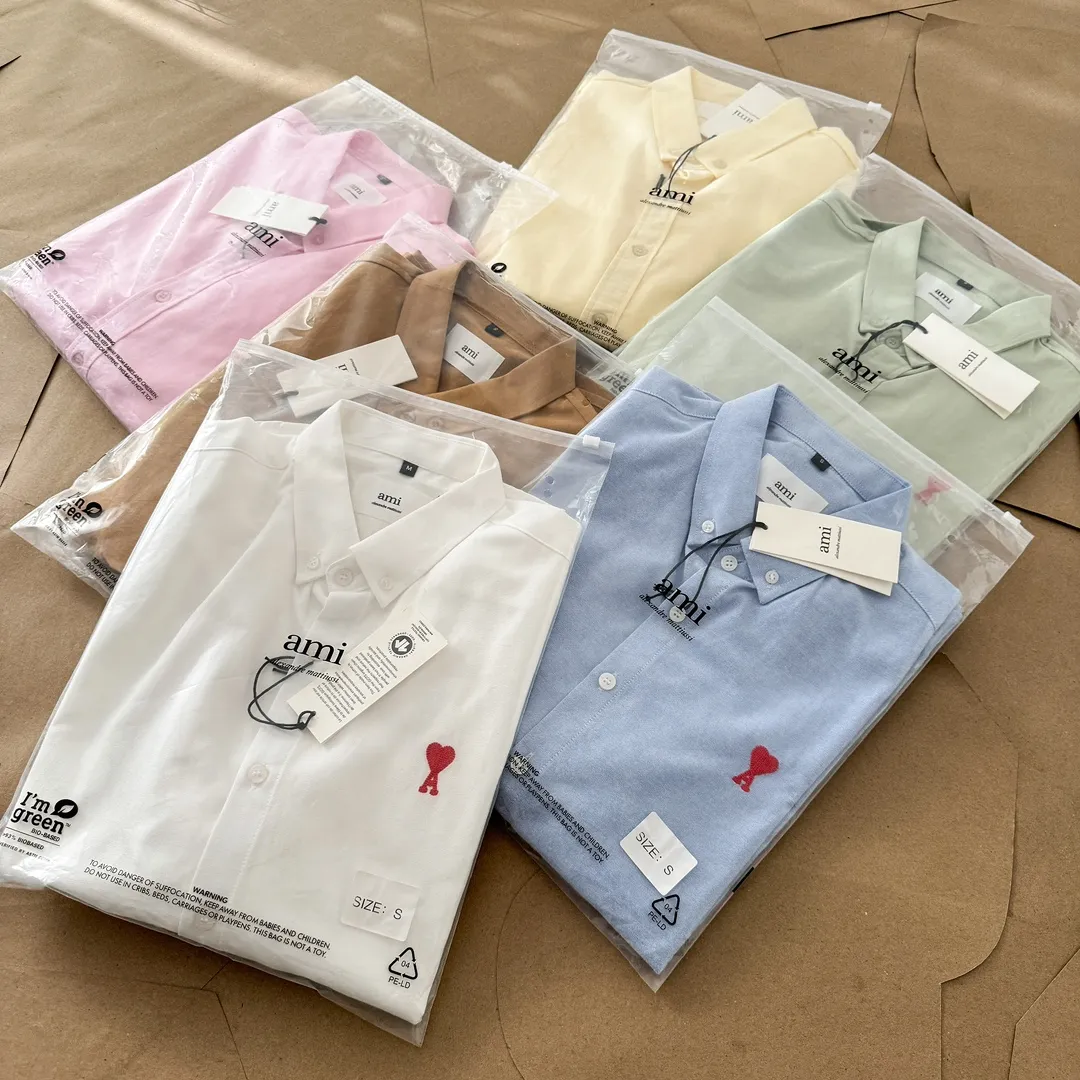 Ami Paris Oxford cotton button-down corner collar casual shirt-small love couple's long-sleeved shirt-same style for men and women. Red small love letter embroidery decoration fashionable and versatile long-sleeved shirt! On sale simultaneously at counters! A well-known French affordable luxury fashion brand. The brand's classic elements are embellishments sought after by major celebrities. Its basic simple design and fashionable style make it a must-have couple's shirt for men and women!  Made of custom-woven 100% Oxford cloth pure cotton, it feels soft and delicate, has excellent moisture absorption and perspiration performance, and is very comfortable and skin-friendly when worn next to the skin! The chest of the shirt is decorated with the classic love letter A logo embroidery. The top-notch embroidery technology is tight, full and full of details, and is cleverly embellished with bright red. It carries all the eye-catching points. It follows the consistent minimalist French attitude. The fabric is soft and comfortable, suitable for any versatile casual shirt couple!  Color: Yellow Pink Green Brown (Loose fit) S-XL is too large White Blue (Standard fit) S-XXL Standard Size: White Blue S-XXL S: Bust 96 Shoulder width 44 Clothing length 68 Sleeve length 58 M: Bust 100 Shoulder width 46 Clothing length 70 Sleeve length 60 L: Bust 104 Shoulder width 48 Clothing length 72 Sleeve length 62 XL: Bust 108, shoulder width 50, dress length 74, sleeve length 63 XXL: Bust 112, shoulder width 52, dress length 76, sleeve length 64 Sizes: Yellow Pink Green Brown S-XL S: Bust 106, shoulder width 47, dress length 71, sleeve length 60 M: Bust 110, shoulder width 48, dress length 73, sleeve length 61 L: Bust 114 Shoulder width 49, clothing length 75, sleeve length 62 XL: Bust 118, shoulder width 50, clothing length 76, sleeve length 63