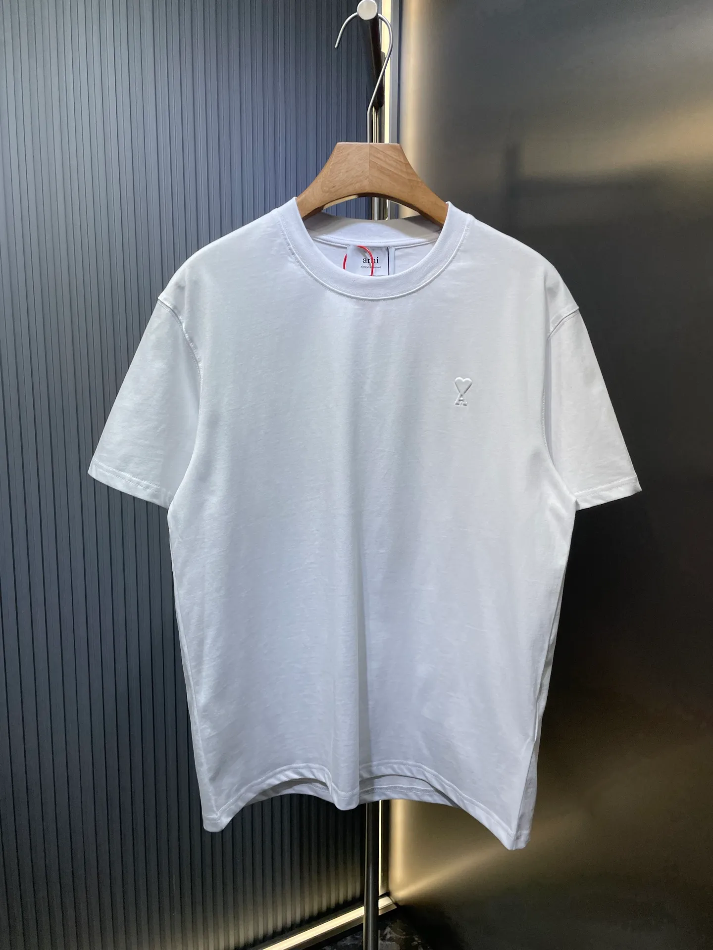 🅿️250 Ami Paris 🌟【Top replica】Love embossed short-sleeved custom-made brocade cotton. Soft and delicate, comfortable and close to the skin. Indulge in the depth of black. The homogeneous three-dimensional love heart jumps on the chest. It is embellished like a work of art. It complements the AMI embroidery on the back and adds brand recognition. It is the ultimate simplification of color and conveys the love and persistence of life. Process 1: High temperature three-dimensional embossing By accurately controlling temperature and pressure, the fiber chains will rearrange to form a three-dimensional concave and convex pattern, showing a unique three-dimensional love effect. Process 2: Using imported machine embroidery technology. Using advanced computer control systems and precision mechanical components to achieve Ami embroidery operations with high precision and smooth and delicate lines. Process 3: The fabrics are washed and have a better hand feel. Not easy to deform, not easy to shrink, not easy to fade, and maintain long-term beauty. Accessories: Customized 1:1 Ami trademark Fit: Loose fit Size: S M L XL