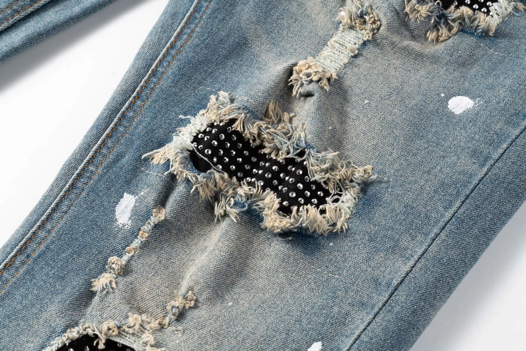 P220 running volume) AMIRI, a trendy brand originating from Los Angeles, was founded by Mike Amiri, who was deeply influenced by street culture and Punk Rock. Its clothing styles are novel and unique, meeting the needs of different fashion players, especially jeans, which are of excellent quality and have been worn by many celebrities. Breaking the traditional production process and cutting, the fabric is soft and skin-friendly, and the details include wrinkles, bullet holes, damage and other designs, making it full of trend. Today I brought you these high street slim jeans with splashes of ink, hot diamonds, white diamonds and washed distressed holes. They are the same style worn by many internet celebrities in Xiaohongshu. Carefully processed by a large washing factory in Ningbo, the front, back, and trouser legs are perfectly faded, giving you a sense of high-end. The destroyed design of the knee part is matched with patchwork leather, which is full of personality. The leather waist nameplate shows the quality, and the custom-made crotch placket hardware is also engraved and molded. The essence of this pair of pants is to destroy the shape and pattern. The master manually frays, cuts and cuts the pants later, which is completely different from the assembly line products. Style number: 1708# Size: 28 (S), 30 (M), 32 (L), 34 (XL)