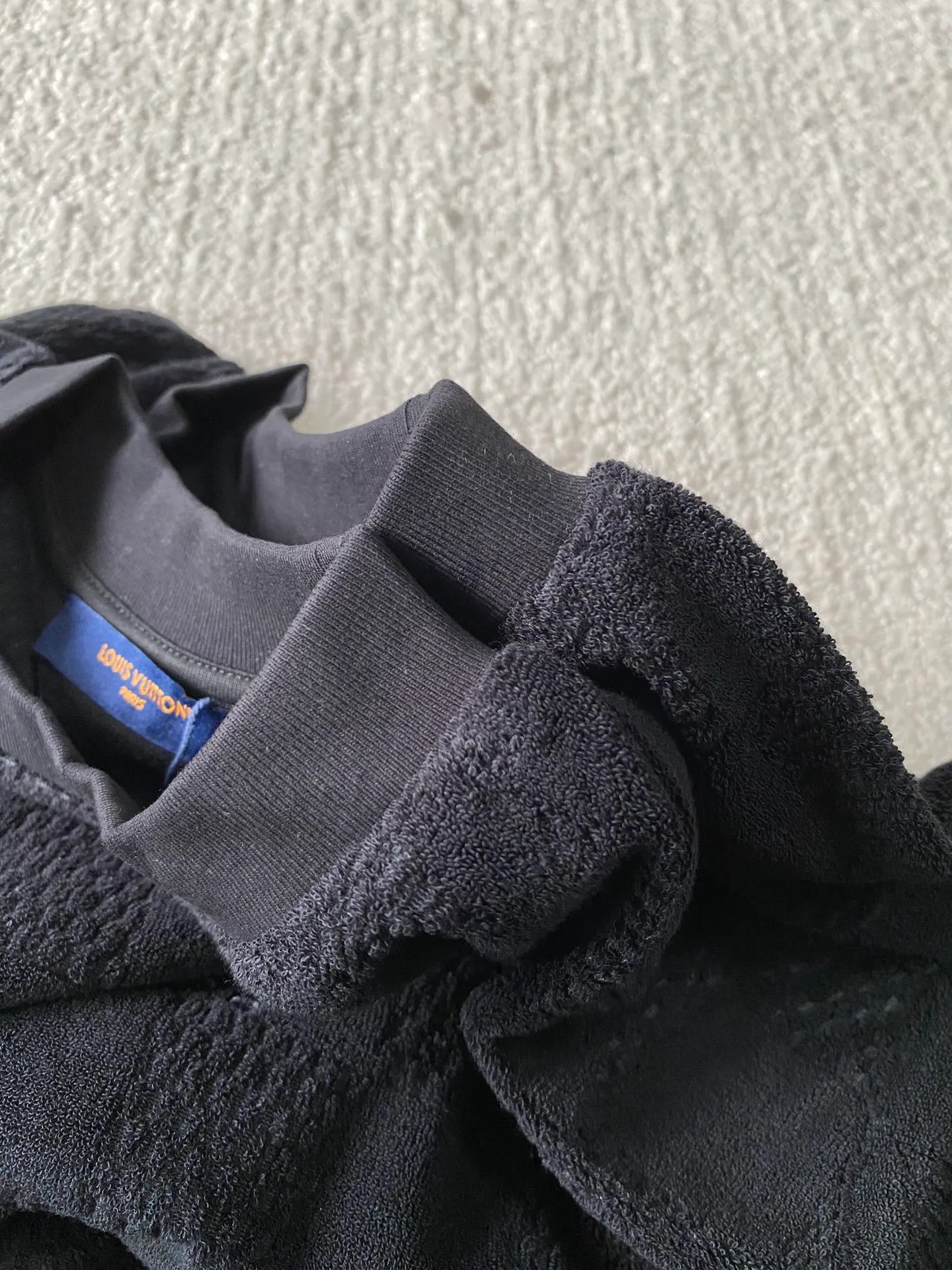 LV towel plaid round neck short sleeves ⚠️Original purchase, 650, standard fit, Damier terry cloth, embroidered Marque L.Uuitton deposee logo on the chest, ribbed collar, floral stitching, full set of accessories with #Damier terry cloth Towel jacquard fabric terry cloth is a fabric that looks like a towel. It has the advantages of high water absorption, good warmth retention, soft hand feel, stiff fabric, and not easy to deform, so it is called terry cloth.  During the weaving process of the full-width embossed pattern, computer digital programming is used to make the plate. The jacquard part has a concave and convex feel, the fabric has a soft and waxy feel, and the fabric details are delicate. The thermal conductivity of towel fabric is low, and because the cotton fiber itself is porous and elastic, a large amount of air can accumulate between the fibers, so the towel fabric has good moisture retention.  #Chest Marque L Uuitton deposee embroidery The chest is embellished with simple letter patterns, and the letter size spacing effect is consistent. Using linen embroidery thread combined with encrypted processing, the embroidery body has a subtle matte visual texture; the embroidery effect is three-dimensional and full. The smaller the embroidery, the more sophisticated and demanding it is. The embroidery thread is made of imported material, which is more flexible and glossy than ordinary embroidery thread; the stitches are clear and smooth, and have a three-dimensional texture effect.  #Positioning Pattern Cutting and Sewing The whole piece positioning pattern sewing process is a fine and complex technology. During the cutting process, it is necessary to ensure that the pattern or texture of each piece can perfectly match other pieces. Through floral tailoring, the checkerboard pattern of ready-made garments appears neatly arranged.  #straight round neck version. Cut and sewed in floral position, standard H hanging version, with shoulder-length design. The vertical version emphasizes that the width of the shoulders, waist, and hem are basically the same, and it is simple and loose. The short sleeves are tailored to fit the body of the wearer. At the same time, the neckline, cuffs and hem of the short sleeves are all designed with double lines.