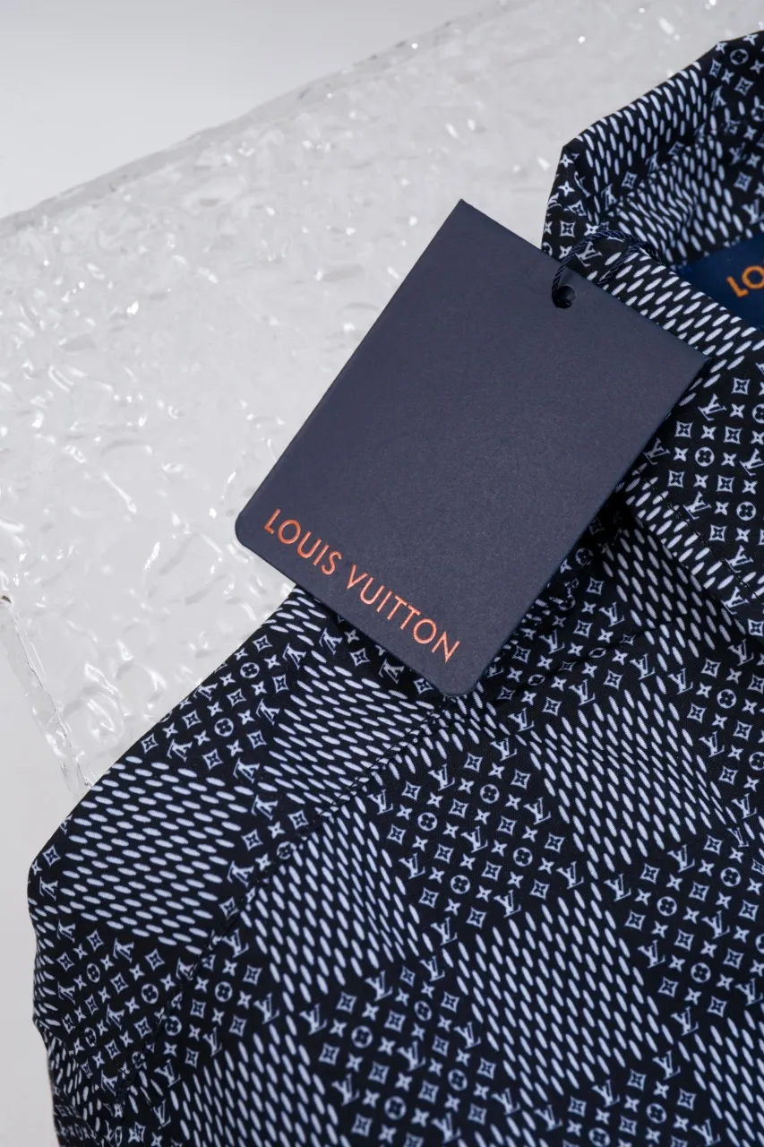 The new LV 24ss short-sleeved shirt is made of lightweight cotton with a full-length Damier Monogram pattern, integrating pocket Monogram elements and the chic Marque L.Vuitton Déposée logo into a checkered pattern. It adds eye-catching style to casual looks and pairs well with the matching beach shorts. Same style for men and women Size: S.M.L.XL