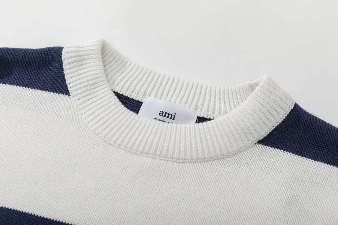 P170 A069# AMI Paris2023 new product. Carefully woven with cotton and wool blended yarn. It has dropped shoulder sleeves and a classic round neck. The blue and white striped body is simple and eye-catching. The red embroidery on the chest easily illustrates the brand identity. Same style for men and women. Color: Black and White, Orchid and White. Size: S-XL.