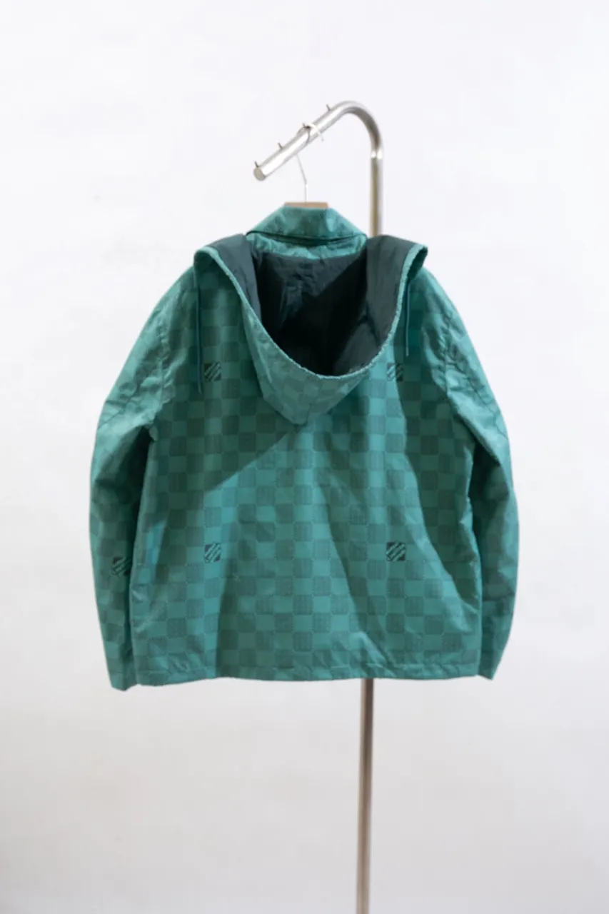 LV Printed Nylon Hooded Windproof Jacket This technical hooded windbreaker combines functional details with the season's nautical theme, sublimating the trend with an all-over Damier Monogram pattern, incorporating micro Monogram details and the Marque L.Vuitton Déposée logo. Fresh colors complete the casual design.  SMLXL
