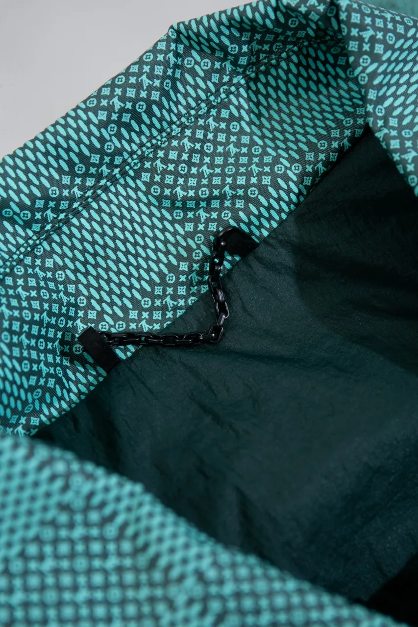 LV Printed Nylon Hooded Windproof Jacket This technical hooded windbreaker combines functional details with the season's nautical theme, sublimating the trend with an all-over Damier Monogram pattern, incorporating micro Monogram details and the Marque L.Vuitton Déposée logo. Fresh colors complete the casual design.  SMLXL