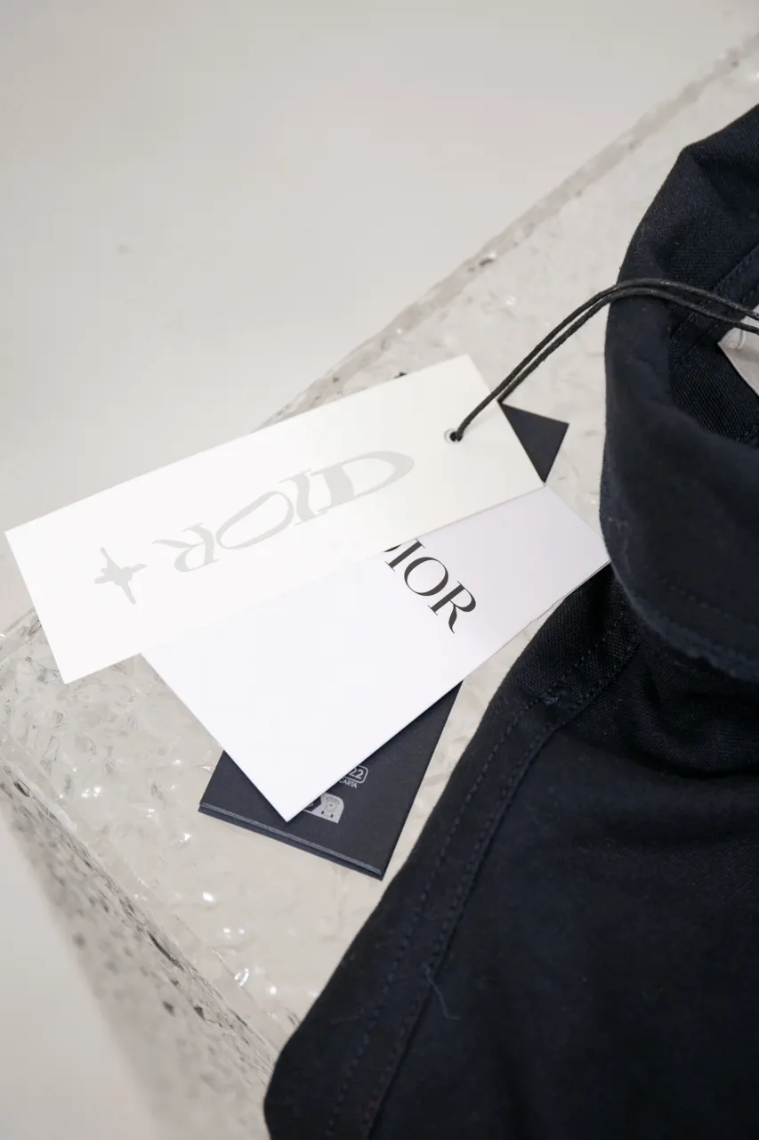 DIOR AND LEWIS HAMILTON Navy blue cotton denim overshirt This overshirt is from the DIOR AND LEWIS HAMILTON limited collection. Crafted from navy blue cotton denim, it features contrasting DIOR AND LEWIS HAMILTON embroidery on the chest and back, a graphic design highlighting Dior's iconic signature. Wear it with the matching jeans for a comfortable, oversized fit. Contrasting DIOR AND LEWIS HAMILTON embroidery on chest and back Button closure and cuffs Chest flap pocket 100% cotton