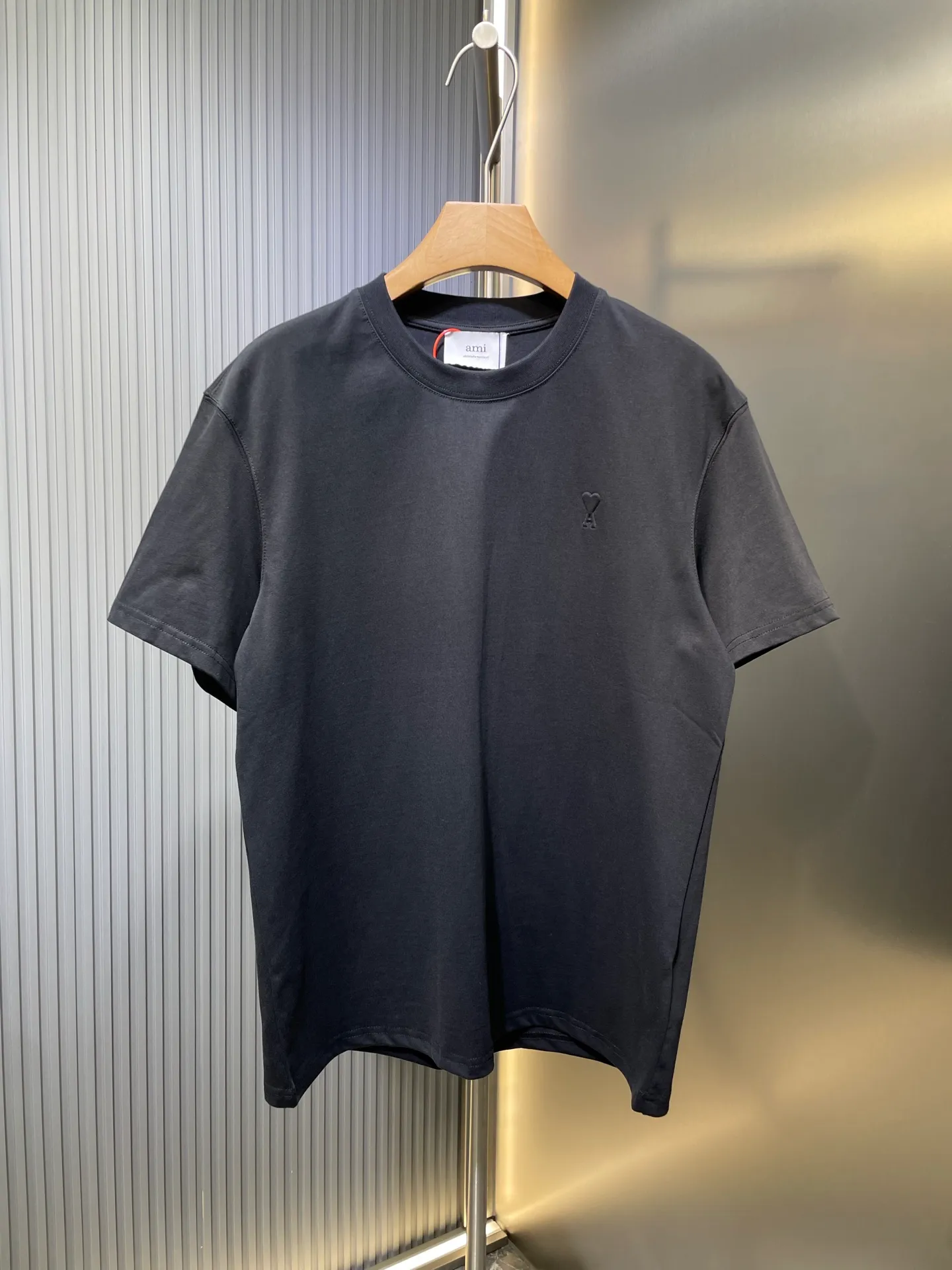 🅿️250 Ami Paris 🌟【Top replica】Love embossed short-sleeved custom-made brocade cotton. Soft and delicate, comfortable and close to the skin. Indulge in the depth of black. The homogeneous three-dimensional love heart jumps on the chest. It is embellished like a work of art. It complements the AMI embroidery on the back and adds brand recognition. It is the ultimate simplification of color and conveys the love and persistence of life. Process 1: High temperature three-dimensional embossing By accurately controlling temperature and pressure, the fiber chains will rearrange to form a three-dimensional concave and convex pattern, showing a unique three-dimensional love effect. Process 2: Using imported machine embroidery technology. Using advanced computer control systems and precision mechanical components to achieve Ami embroidery operations with high precision and smooth and delicate lines. Process 3: The fabrics are washed and have a better hand feel. Not easy to deform, not easy to shrink, not easy to fade, and maintain long-term beauty. Accessories: Customized 1:1 Ami trademark Fit: Loose fit Size: S M L XL