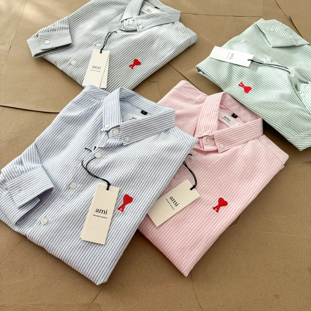Ami Paris Oxford cotton button-down corner collar casual shirt - small love striped couple's long-sleeved shirt - same style for men and women. Red small love letter embroidery decoration, fashionable and versatile long-sleeved shirt! On sale simultaneously at counters! A well-known French affordable luxury fashion brand. The brand's classic elements are embellishments sought after by major celebrities. Its basic simple design and fashionable style make it a must-have couple's shirt for men and women!  Made of custom-woven 100% Oxford cloth pure cotton, it feels soft and delicate, has excellent moisture absorption and perspiration performance, and is very comfortable and skin-friendly when worn next to the skin! The chest of the shirt is decorated with the classic love letter A logo embroidery. The top-notch embroidery technology is tight, full and full of details, and is cleverly embellished with bright red. It carries all the eye-catching points. It follows the consistent minimalist French attitude. The fabric is soft and comfortable, suitable for any versatile casual shirt couple!  Color: Blue Green Pink Gray Size: S-XXL S: Bust 96 Shoulder 44 Length 68 Sleeve 58 M: Bust 100 Shoulder 46 Length 70 Sleeve 60 L: Bust 104 Shoulder 48 Length 72 Sleeve 62 XL: Bust 108 Shoulder 50 Length 74 Sleeve 63 XXL: Bust 112, shoulder width 52, length 76, sleeve length 64
