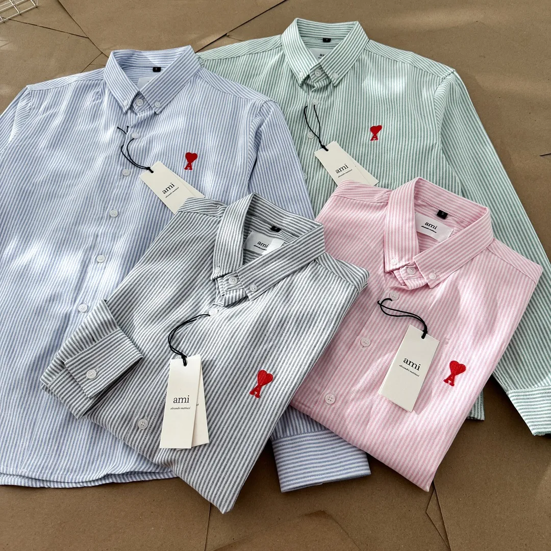 Ami Paris Oxford cotton button-down corner collar casual shirt - small love striped couple's long-sleeved shirt - same style for men and women. Red small love letter embroidery decoration, fashionable and versatile long-sleeved shirt! On sale simultaneously at counters! A well-known French affordable luxury fashion brand. The brand's classic elements are embellishments sought after by major celebrities. Its basic simple design and fashionable style make it a must-have couple's shirt for men and women!  Made of custom-woven 100% Oxford cloth pure cotton, it feels soft and delicate, has excellent moisture absorption and perspiration performance, and is very comfortable and skin-friendly when worn next to the skin! The chest of the shirt is decorated with the classic love letter A logo embroidery. The top-notch embroidery technology is tight, full and full of details, and is cleverly embellished with bright red. It carries all the eye-catching points. It follows the consistent minimalist French attitude. The fabric is soft and comfortable, suitable for any versatile casual shirt couple!  Color: Blue Green Pink Gray Size: S-XXL S: Bust 96 Shoulder 44 Length 68 Sleeve 58 M: Bust 100 Shoulder 46 Length 70 Sleeve 60 L: Bust 104 Shoulder 48 Length 72 Sleeve 62 XL: Bust 108 Shoulder 50 Length 74 Sleeve 63 XXL: Bust 112, shoulder width 52, length 76, sleeve length 64