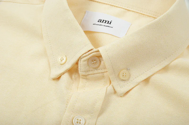 AMI Paris classic autumn heart embroidery in the same color on the chest. Casual cotton solid color short-sleeved Oxford shirt. Original custom-made 180g pure cotton fabric. Loose off-shoulder version. Same style for men and women. Color: Tianlan, white, green, pink, yellow, size: S-XL