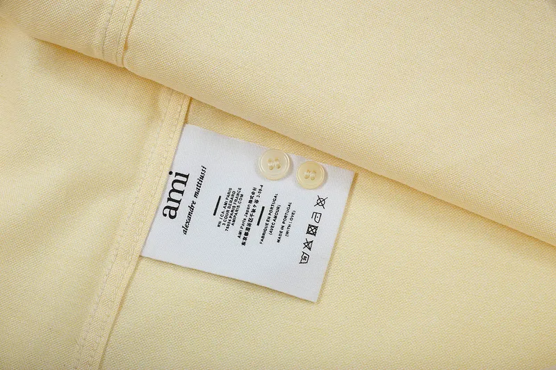 AMI Paris classic autumn heart embroidery in the same color on the chest. Casual cotton solid color short-sleeved Oxford shirt. Original custom-made 180g pure cotton fabric. Loose off-shoulder version. Same style for men and women. Color: Tianlan, white, green, pink, yellow, size: S-XL