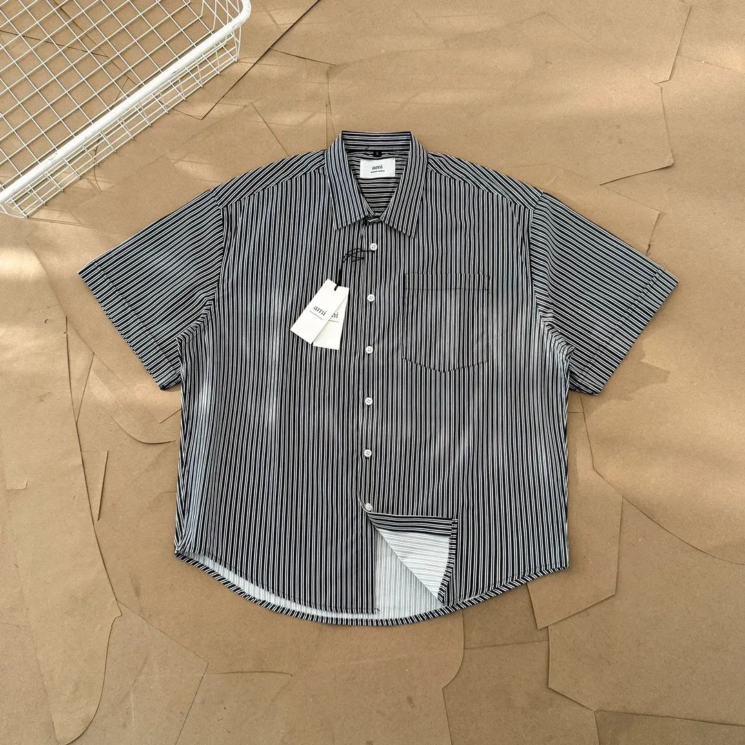 Ami Paris men's 24 spring and summer new love style loose cotton striped short shirt with the same color love at the back of the neck - the same style for men and women. The same color small love embroidery decoration at the back of the neck is fashionable and versatile long-sleeved shirt! On sale simultaneously at counters!  A well-known French affordable luxury fashion brand. The brand's classic elements are embellishments sought after by major celebrities. Its basic simple design and fashionable style make it a must-have couple's shirt for men and women!  Made of custom-woven 100% silk cotton material, it feels soft and delicate, has excellent moisture absorption and perspiration performance, and is very comfortable and skin-friendly when worn next to the skin! The simple and versatile pockets on the chest follow the consistent minimalist French attitude. The fabric is soft and comfortable, suitable for any versatile casual shirt couple!  Color: Blue Black Size: S-XL S: Bust 102, Shoulder 47, Length 70 M: Bust 106, Shoulder 48, Length 72 L: Bust 110, Shoulder 49, Length 74 XL: Bust 114, Shoulder 50, Length 76