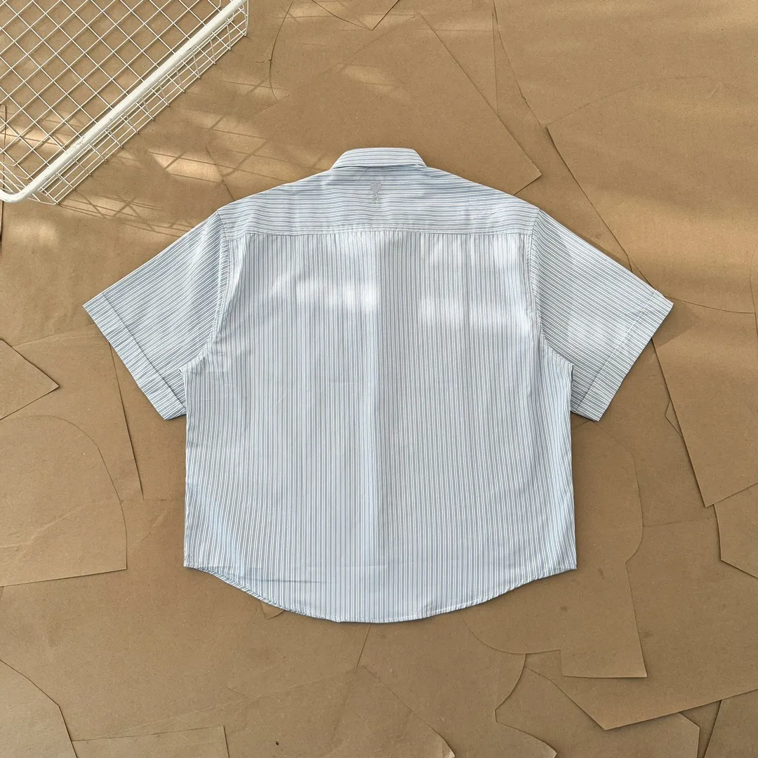 Ami Paris men's 24 spring and summer new love style loose cotton striped short shirt with the same color love at the back of the neck - the same style for men and women. The same color small love embroidery decoration at the back of the neck is fashionable and versatile long-sleeved shirt! On sale simultaneously at counters!  A well-known French affordable luxury fashion brand. The brand's classic elements are embellishments sought after by major celebrities. Its basic simple design and fashionable style make it a must-have couple's shirt for men and women!  Made of custom-woven 100% silk cotton material, it feels soft and delicate, has excellent moisture absorption and perspiration performance, and is very comfortable and skin-friendly when worn next to the skin! The simple and versatile pockets on the chest follow the consistent minimalist French attitude. The fabric is soft and comfortable, suitable for any versatile casual shirt couple!  Color: Blue Black Size: S-XL S: Bust 102, Shoulder 47, Length 70 M: Bust 106, Shoulder 48, Length 72 L: Bust 110, Shoulder 49, Length 74 XL: Bust 114, Shoulder 50, Length 76