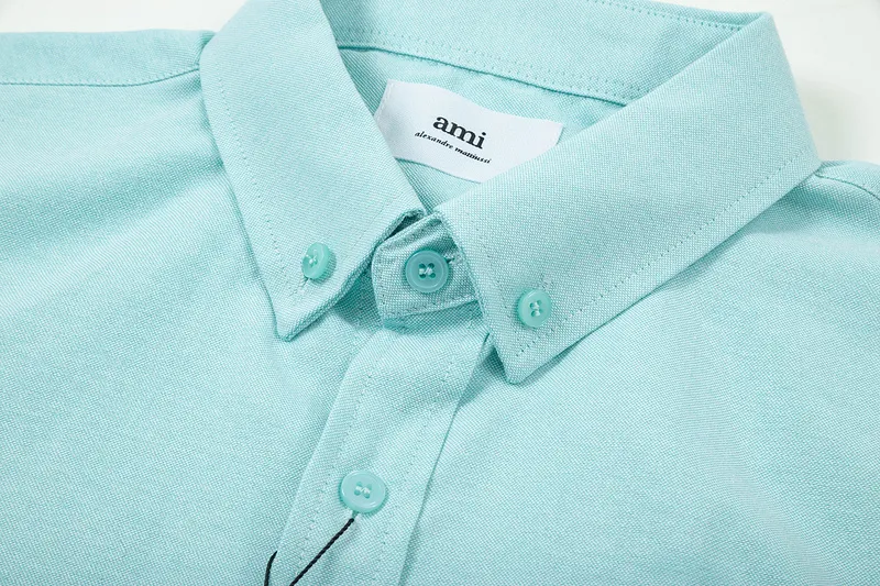 AMI Paris classic autumn heart embroidery in the same color on the chest. Casual cotton solid color short-sleeved Oxford shirt. Original custom-made 180g pure cotton fabric. Loose off-shoulder version. Same style for men and women. Color: Tianlan, white, green, pink, yellow, size: S-XL