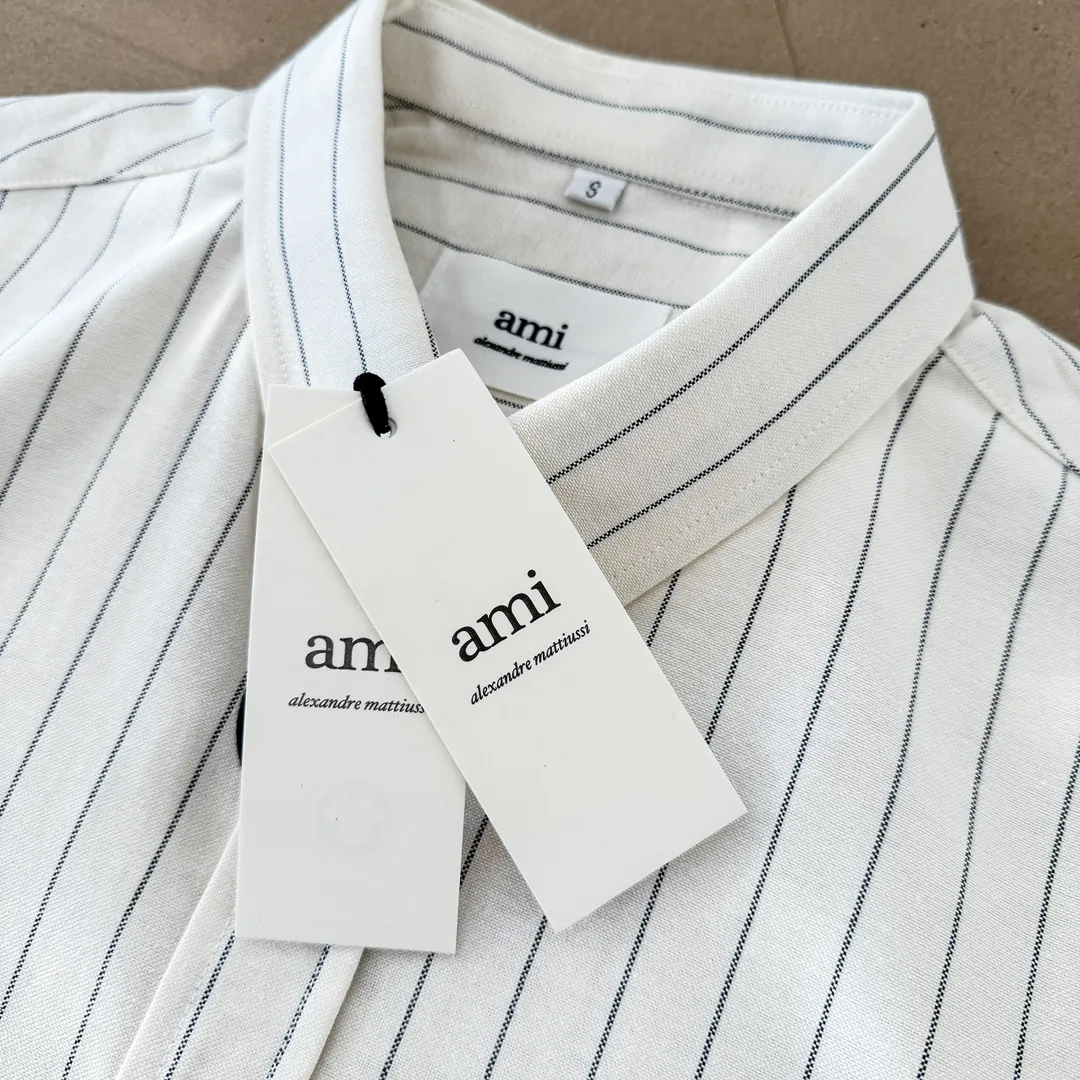Ami Paris Oxford cloth cotton button-down corner collar casual shirt-little red heart striped couple's long-sleeved shirt-same style for men and women. Red little love letter embroidery decoration fashionable and versatile long-sleeved shirt! On sale simultaneously at counters!  A well-known French affordable luxury fashion brand. The brand's classic elements are embellishments sought after by major celebrities. Its basic simple design and fashionable style make it a must-have couple's shirt for men and women!  Made of custom-woven 100% Oxford cloth pure cotton, it feels soft and delicate, has excellent moisture absorption and perspiration performance, and is very comfortable and skin-friendly when worn next to the skin! The chest of the shirt is decorated with the classic love letter A logo embroidery. The top-notch embroidery technology is tight, full and full of details, and is cleverly embellished with bright red. It carries all the eye-catching points. It follows the consistent minimalist French attitude. The fabric is soft and comfortable, suitable for any versatile casual shirt couple!  Color: off-white Size: S-XXL S: Bust 96 Shoulder width 44 Length 68 Sleeve length 58 M: Bust 100 Shoulder width 46 Length 70 Sleeve length 60 L: Bust 104 Shoulder width 48 Length 72 Sleeve length 62 XL: Bust 108 Shoulder width 50 Length 74 Sleeve length 63 XXL: Bust 112 Shoulder width 52, clothing length 76, sleeve length 64