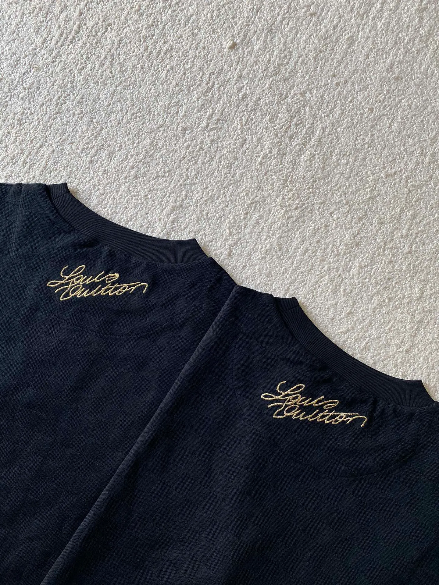 LV Golden Dog Chapter Round Neck Short Sleeve ⚠️Original purchase, 750; concealed jacquard fabric, standard version, full Damier jacquard pique, embellished with Dog Blason patch on the chest and embroidered handwritten Louis Vuitton logo # # on the back. Fully silk jacquard fabric, using 50S double-stranded silk, 210g; with 32S double yarn thread, 300g. The smooth jacquard fabric uses silk threads with better gloss as warp and weft threads, and uses complex jacquard technology to weave delicate and exquisite triangular patterns on the entire fabric. The fabric not only has a beautiful appearance and feel, but also has an overall higher quality feel. The silk jacquard fabric design adds a unique charm to the product through exquisite patterns and textures.  # The chest is embellished with Dog Blason patches and embroidered seals. The logo is made of imported custom-made embroidery thread. The glossy mercerized embroidery thread is dyed to give it a uniform and glossy finish. The exquisite embroidery machine combines complex embroidery needlework and fine detail processing to create a three-dimensional micro-relief embroidery effect.  Gold thread needle embroidery is a delicate and decorative embroidery technique. It is made of metal alloy threads with tight stitches, bright colors and high gloss. Wrap the gold wire around the spool, making sure the thread ends are neat and easy to manipulate to create a tight stitch.  # Imported embroidery thread plain embroidery technology. The handwritten embroidery is designed based on the original size and size to restore the overall three-dimensional visual effect. Using linen embroidery thread combined with encrypted processing, the embroidery body has a subtle matte visual texture; the embroidery effect is three-dimensional and full. The embroidery is very fine, the stitches are dense, the fonts are clear and the lines and three-dimensional feel are strong.  # Straight round neck version. Standard H hanging version, with shoulder-length design. The vertical version emphasizes that the width of the shoulders, waist, and hem are basically the same, and it is simple and loose. The short sleeves are tailored to fit the body of the wearer. At the same time, the neckline, cuffs and hem of the short sleeves are all designed with double lines.