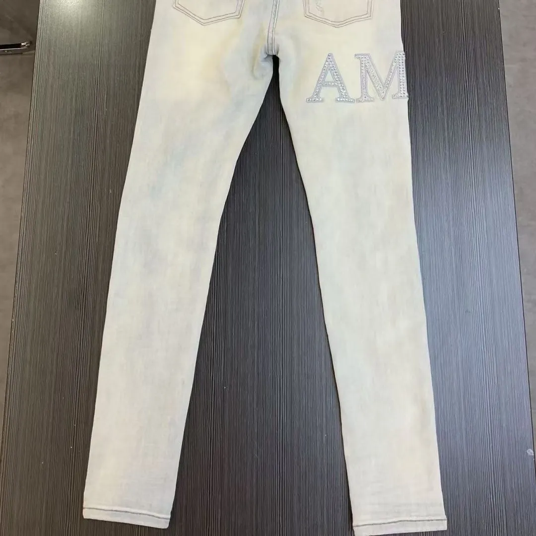 P156 model number Cc818 AMIRI white ripped high street jeans with diamonds! The transliteration of amiri is Emil, which is the name of the founder. Mike Amiri, the founder of amiri, grew up in Los Angeles, USA. He was influenced by local street culture and Punk Rock since he was a child, so he founded the amiri brand named after himself. A variety of trendy clothing meets the needs of different fashion players. Amiri clothing has novel and unique styles and is a well-known street brand in the United States. The styles and styles of many clothes are loved by many street photographers. The various clothing styles meet the dressing needs of different people, show their unique temperament, and show the trend of dressing. amiri's jeans are relatively famous. Not only do they have many styles, but the quality of their denim jackets is also very good. Many celebrities have also worn the amiri brand's denim series. The fabric is made of 100% cotton denim! High temperature setting, heavy sand washing, never fade, full of fashion! All made to order! -The colorful embroidery on the chest is so tense and the embroidery is neat! Imported machine for work! quality assurance!  -The entire garment is made with fine workmanship. Each seam is pressed using a double-needle machine. This stitching is a test of the workers' skills. If it goes astray, the entire garment will be scrapped. The hardware is custom-made, with exclusive logos, and is a one-to-one replica of the original! Original trademark! The fit is loose and slimming! Color: Picture color Size: m-2xl