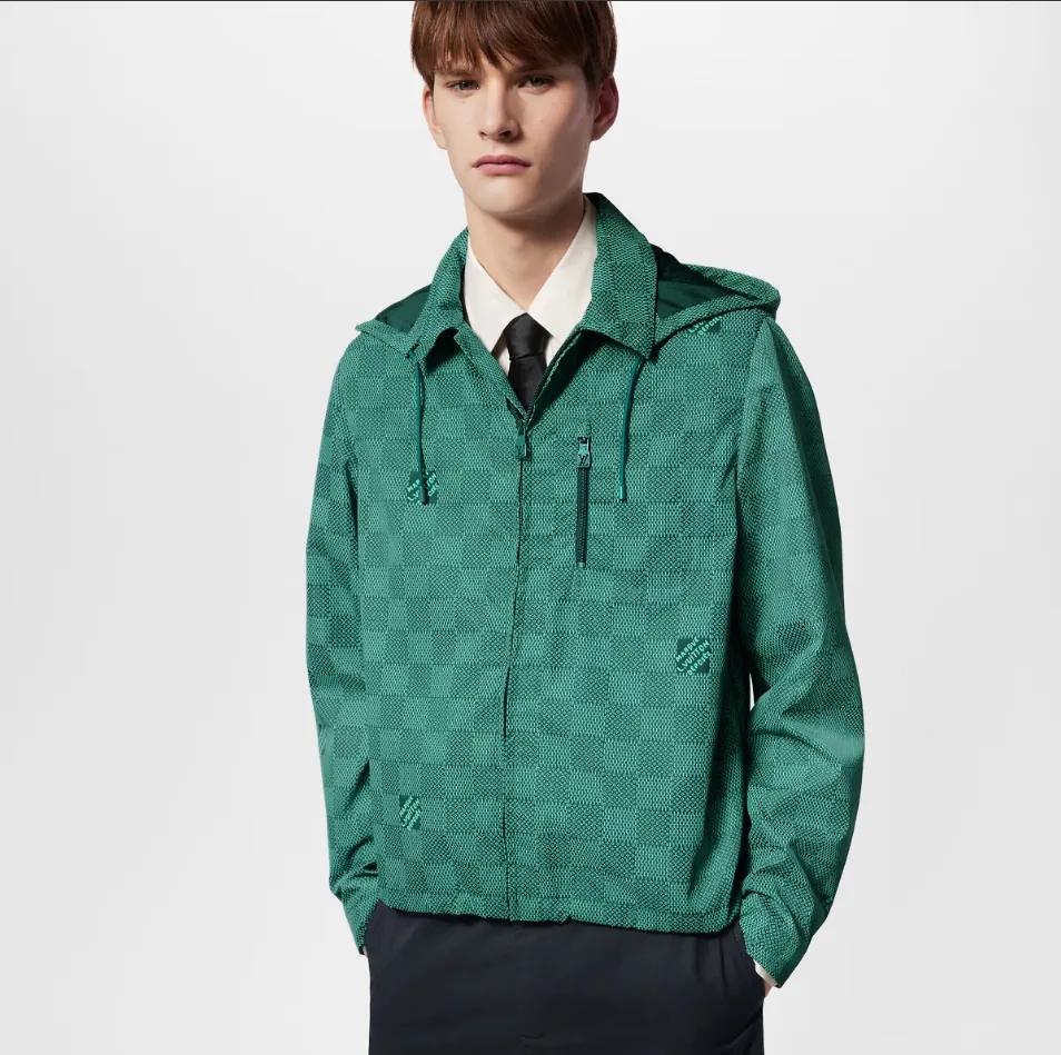 Upper body photo LV printed nylon hooded windproof jacket This technical hooded windproof jacket shows a harmonious blend of functional details and the season's nautical theme. It sublimates the trend style with an all-over Damier Monogram pattern, which is integrated with micro Monogram details and the Marque L.Vuitton Déposée logo. Fresh colors complete the casual design.  SMLXL