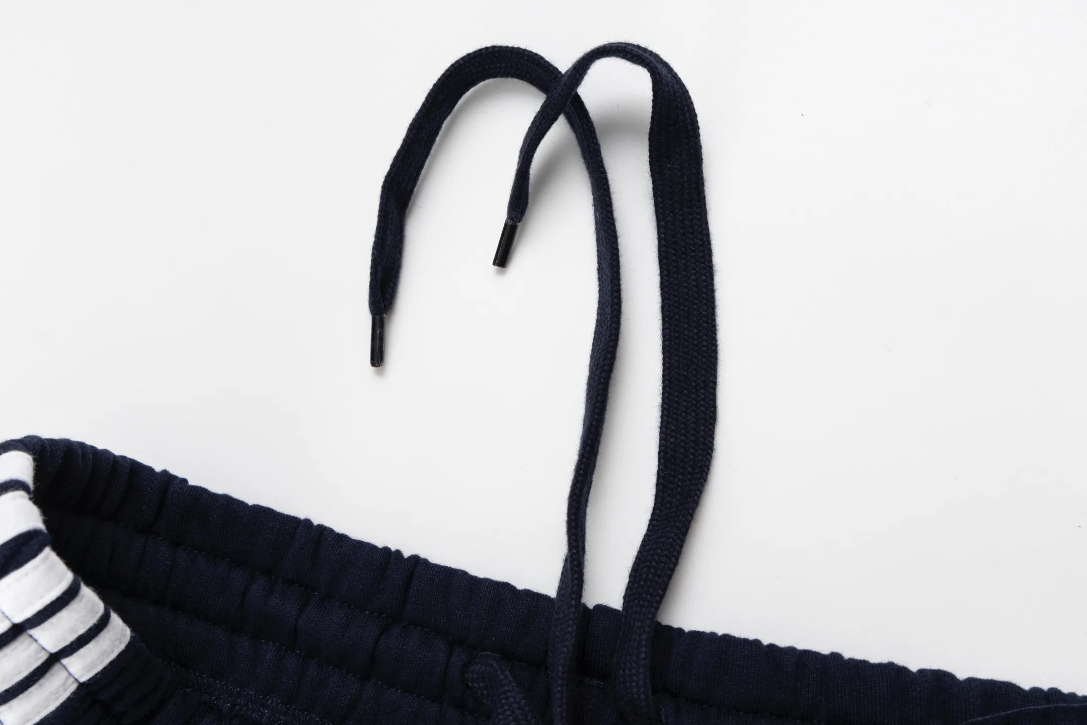 🅿️480 [Exclusive supply] BLCG circular embroidered webbing sweatpants. The fabric is made of single-sided fish scale fabric woven with cotton as the base. The front is a smooth knitted surface, and the skin-contacting surface is formed into three-dimensional terry through the floating thread knitting technology of the knitting machine, which increases the fluffiness and has a delicate touch. The terry structure absorbs a large amount of water and evaporates quickly, so it is not easy to loosen and deform after repeated washing. Using an imported embroidery machine with 3000 stitches, the front thigh is decorated with loop sports icon embroidery. The double-axis linear guide drives the embroidery frame, and the frame moving accuracy can reach 0.01mm/P, ensuring precise positioning of the embroidery pattern. The decorative strips are precisely positioned along the designated contours from the waist to the toes to ensure symmetry and overall smoothness. Before actual sewing, use very fine basting stitches for pre-fixing. This step is crucial to prevent the trim from slipping, twisting, or wrinkling during the sewing process and ensuring that the final stitch is straight and perfect. By actively interfering with the shrinkage potential of the cotton knitted surface, the fabric is able to transition from changeable to stable, improving dimensional stability while being less prone to deformation and wrinkles. Size:S/M/L/XL