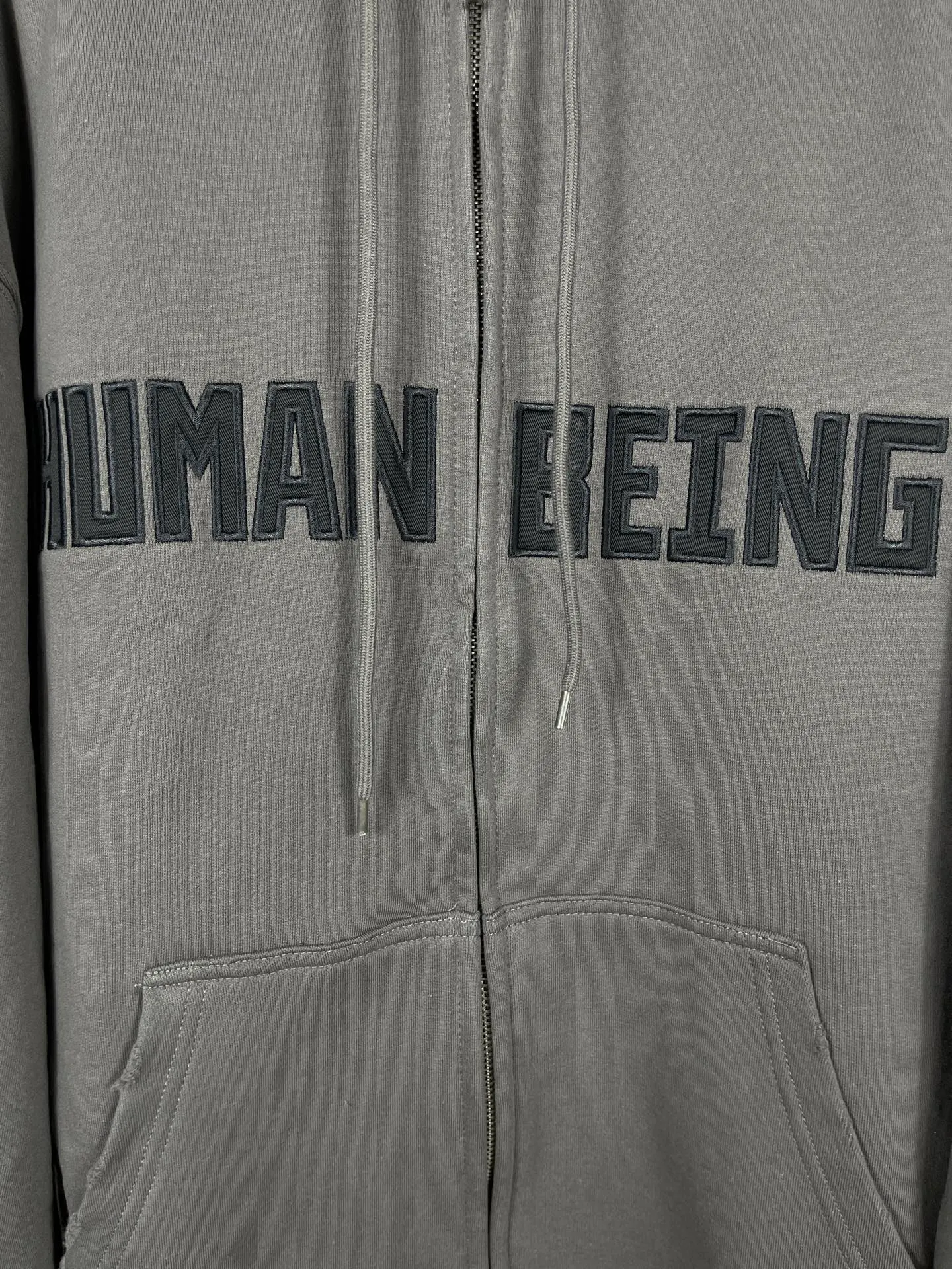 🅿️370 real photos [Top version. Official website quality] BALENCI*GA/Paris. 2025 new model. HUMAN BEING letter patch embroidered hooded zipper cardigan sweatshirt. Brick cabinets are synchronized. Genuine products are developed at the first time, and you can print and compare! The fabric is made of Paris ZP custom-woven and dyed cotton sweatshirt. Weighing 460 grams, the cloth surface is clean. The cloth pattern is clear, soft and comfortable. The threads are dyed with no color difference. The embroidery is done on a genuine Tajima embroidery machine. The letters are clear and the effect is three-dimensional. The version adopts OS loose shoulder design. Same style for men and women. Code: BL259938 Color: Smoke Gray Size: XS S M L