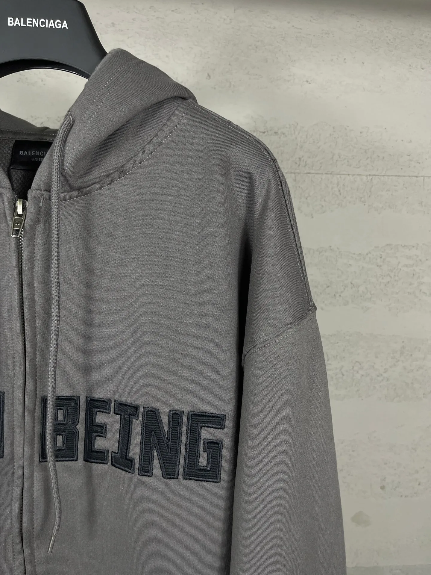 🅿️370 real photos [Top version. Official website quality] BALENCI*GA/Paris. 2025 new model. HUMAN BEING letter patch embroidered hooded zipper cardigan sweatshirt. Brick cabinets are synchronized. Genuine products are developed at the first time, and you can print and compare! The fabric is made of Paris ZP custom-woven and dyed cotton sweatshirt. Weighing 460 grams, the cloth surface is clean. The cloth pattern is clear, soft and comfortable. The threads are dyed with no color difference. The embroidery is done on a genuine Tajima embroidery machine. The letters are clear and the effect is three-dimensional. The version adopts OS loose shoulder design. Same style for men and women. Code: BL259938 Color: Smoke Gray Size: XS S M L