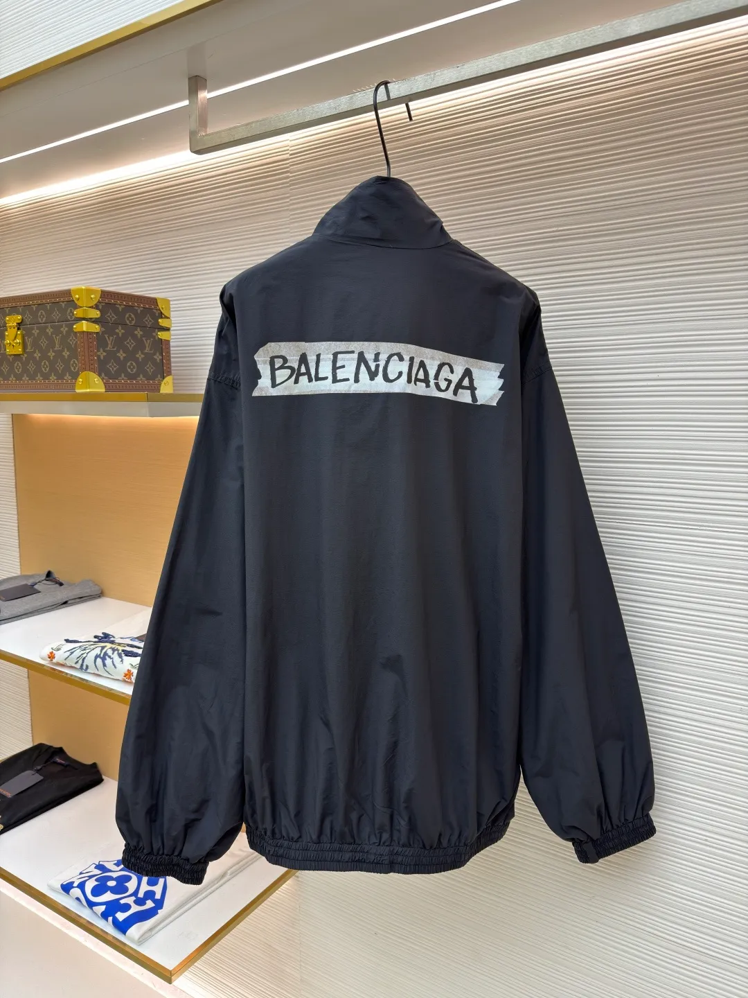 Balenciaga glue print jacket ●Original version: Purchased and developed for 20000 ●Item number: 1682403-B40 ●Fabric: woven nylon fabric ●Technology: glue printing production ●Color: black ●Version: fitted version ●Weight: about 480 grams ●Size: XS-S-M ●Description: This Balenciaga cotton blended jacket is made of 65% cotton and 35% polyester fiber blended fabric. It is first processed by a high-temperature pre-shrinking process to control the fabric shrinkage within 1% to avoid deformation after wearing and washing. The brand logo on the front of the body is made using glue printing technology. Before printing, the fabric is statically eliminated, and then the glue is tightly combined with the fabric through 150℃ high temperature printing. The pattern is clear, does not fall off and is friction-resistant. The jacket adopts a stand-up collar zipper design. The metal zipper has been treated with anti-oxidation plating and is smooth and easy to pull. The cuffs and hem are made of elastic ribbing. The rib weaving method is 1*1 double-needle technology, which is durable and not easy to loosen. The side seam pockets use invisible inlay technology with a stitch density of 8 stitches per centimeter. The shoulders are seamlessly taped. The overall craftsmanship takes into account the brand's iconic simple design and durability, and the details highlight the production standards of high-end clothing. The overall wiring is straight and delicate, the fabric is comfortable and soft, and the color is consistent without color difference. It can be matched with the same style to create a fashionable look and control various occasions. Customized accessories, complete with three standards, same style for men and women!