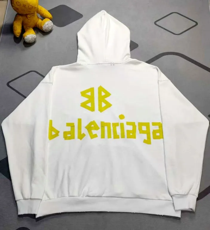 The top proven version of Balenciaga 23SS masking paper printed letters double-sided logo hooded loose hooded sweatshirt. This hoodie has a very interesting and cute design. The kangaroo pocket on the front of the large body is reverse-cut design. The double side pockets are hollow, which means that when viewed from the front, it actually deceives your vision. The real pockets are sewn on the reverse terry bottom. It is time-consuming and labor-intensive, but it is the core theme of the entire hoodie that cannot be ignored. The same detail is that the double side pockets are hemmed and stitched. And processed with holes; 480g heavy-weight pure cotton fabric with fine small terry bottom. After heavy mud dyeing and washing, the fabric still has a thick foundation and is comfortable and soft. The front and back double-sided textured paper transfer LOGO, and the front and back printing colors are different. The loose and large drop shoulder design is unisex. This style is also very suitable for girls to match. It is easy to create a lazy and casual street feel of the United States and France. Many holes are processed by hand grinding wheels on the body. Traces of muddying can be seen on the neckline, shoulder line, and side cuff splicing, but the visual effect transition is natural and soft without any sense of dirt. The old effect of the entire hoodie is excellent. The cuff threads are custom-woven in color; the packaging is washed and customized. The new gray silver letter main logo. The dropped shoulder model does not include shoulder width. The version is Kanye’s American style. Short and wide street casual version. From short sleeves to sweaters, this style is definitely not to be missed. Color: mud-dyed custom-woven navy Size: XS-S-M (Can be worn by both men and women, OS is loose and dropped on the shoulders) P:510