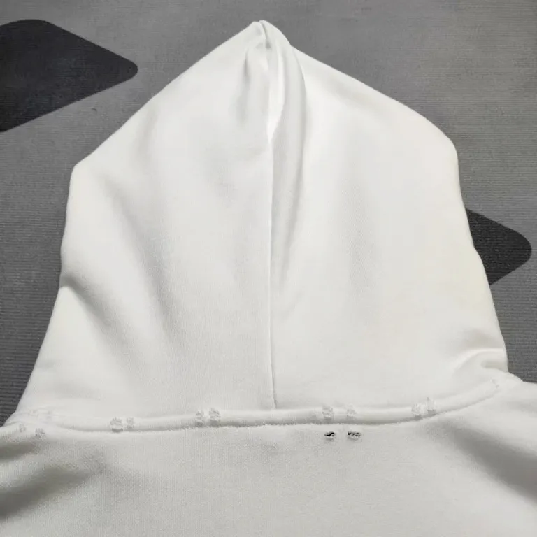 The top proven version of Balenciaga 23SS masking paper printed letters double-sided logo hooded loose hooded sweatshirt. This hoodie has a very interesting and cute design. The kangaroo pocket on the front of the large body is reverse-cut design. The double side pockets are hollow, which means that when viewed from the front, it actually deceives your vision. The real pockets are sewn on the reverse terry bottom. It is time-consuming and labor-intensive, but it is the core theme of the entire hoodie that cannot be ignored. The same detail is that the double side pockets are hemmed and stitched. And processed with holes; 480g heavy-weight pure cotton fabric with fine small terry bottom. After heavy mud dyeing and washing, the fabric still has a thick foundation and is comfortable and soft. The front and back double-sided textured paper transfer LOGO, and the front and back printing colors are different. The loose and large drop shoulder design is unisex. This style is also very suitable for girls to match. It is easy to create a lazy and casual street feel of the United States and France. Many holes are processed by hand grinding wheels on the body. Traces of muddying can be seen on the neckline, shoulder line, and side cuff splicing, but the visual effect transition is natural and soft without any sense of dirt. The old effect of the entire hoodie is excellent. The cuff threads are custom-woven in color; the packaging is washed and customized. The new gray silver letter main logo. The dropped shoulder model does not include shoulder width. The version is Kanye’s American style. Short and wide street casual version. From short sleeves to sweaters, this style is definitely not to be missed. Color: mud-dyed custom-woven navy Size: XS-S-M (Can be worn by both men and women, OS is loose and dropped on the shoulders) P:510