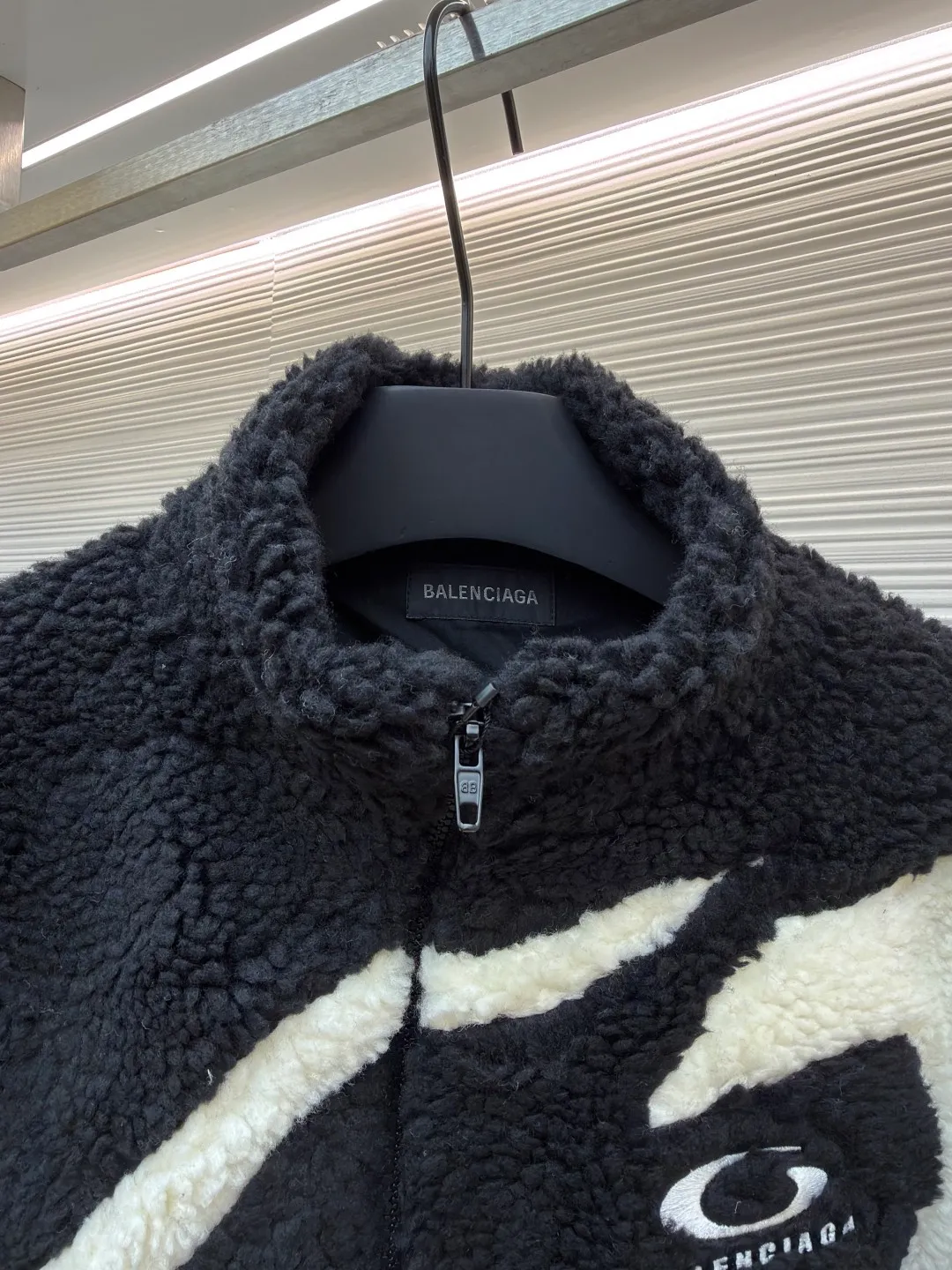Balenciaga ski series sherpa stand collar jacket ●Original version: purchased and developed by 14616 ●Item number: 1681957-B50 ●Fabric: sherpa fabric ●Technology: made on positioning cutting machine ●Color: black and white ●Version: fitted version ●Weight: about 1190 grams ●Size: XXS-XS-S-M ●Description: Made of high-density imitation lamb wool fabric, the black/white two-color terry is pre-shrunk, making the velvet feel fluffy and not easy to shed. The core pattern of the body is a three-dimensional splicing process: the white terry pieces are precisely cut by laser, and the edges are sewn by hand stitching to form a smooth curve layer with the black base, and the error is controlled within 0.2cm. The chest logo uses a combination of flocking embossing and offset printing, and the brand words and patterns have both a three-dimensional feel and wear resistance. The placket is equipped with a hidden metal zipper, and the chain teeth are matte black-plated, making it smooth and visually low-key. The cuffs and hem are ribbed with the same fabric, and the elastic rebound rate is ≥90%. The inner lining is lined with light polyester fiber interlining to improve the comfort of putting on and taking off. The overall stitching is made of high-tenacity nylon thread. The even stitch length of 9 needles per centimeter takes into account both warmth retention and style. The overall wiring is straight and delicate, the fabric is comfortable and soft, and the color is consistent without color difference. It can be matched with the same style to create a fashionable look and control various occasions. Customized accessories, complete with three standards, same style for men and women!
