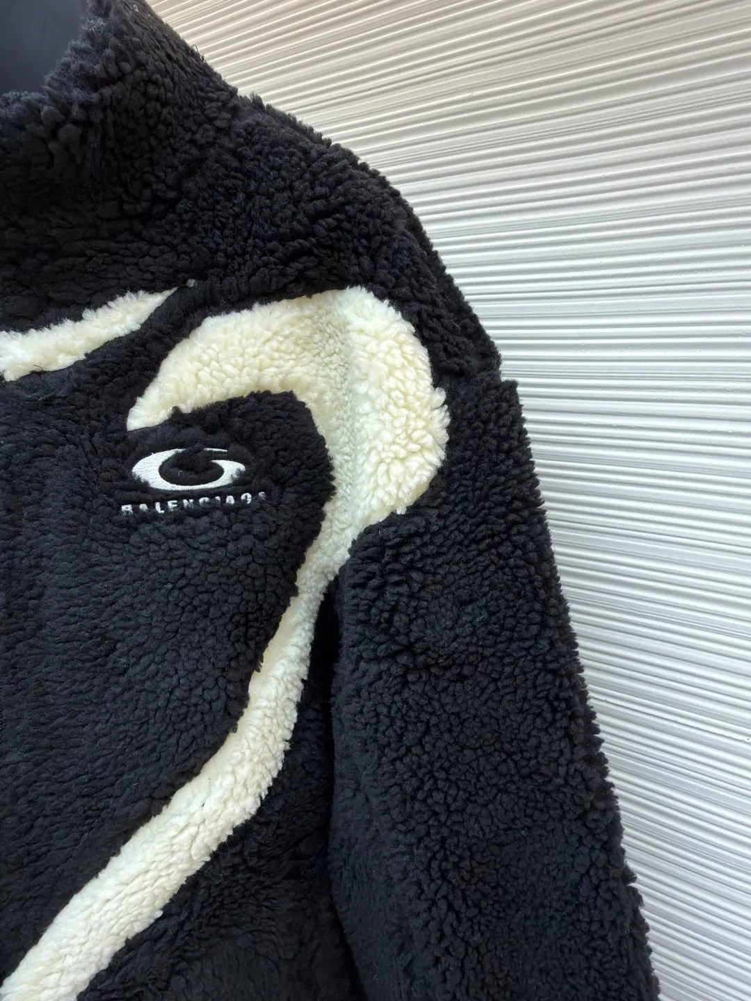 Balenciaga ski series sherpa stand collar jacket ●Original version: purchased and developed by 14616 ●Item number: 1681957-B50 ●Fabric: sherpa fabric ●Technology: made on positioning cutting machine ●Color: black and white ●Version: fitted version ●Weight: about 1190 grams ●Size: XXS-XS-S-M ●Description: Made of high-density imitation lamb wool fabric, the black/white two-color terry is pre-shrunk, making the velvet feel fluffy and not easy to shed. The core pattern of the body is a three-dimensional splicing process: the white terry pieces are precisely cut by laser, and the edges are sewn by hand stitching to form a smooth curve layer with the black base, and the error is controlled within 0.2cm. The chest logo uses a combination of flocking embossing and offset printing, and the brand words and patterns have both a three-dimensional feel and wear resistance. The placket is equipped with a hidden metal zipper, and the chain teeth are matte black-plated, making it smooth and visually low-key. The cuffs and hem are ribbed with the same fabric, and the elastic rebound rate is ≥90%. The inner lining is lined with light polyester fiber interlining to improve the comfort of putting on and taking off. The overall stitching is made of high-tenacity nylon thread. The even stitch length of 9 needles per centimeter takes into account both warmth retention and style. The overall wiring is straight and delicate, the fabric is comfortable and soft, and the color is consistent without color difference. It can be matched with the same style to create a fashionable look and control various occasions. Customized accessories, complete with three standards, same style for men and women!