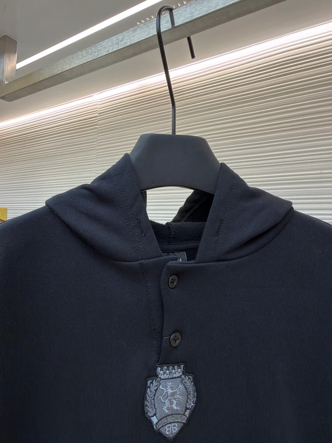 Balenciaga 3B football Polo hoodie ●Original version: Purchased and developed for 9999 ●Item number: 1681997-B40 ●Fabric: cotton fabric ●Technology: embroidery applique production ●Color: black ●Version: loose fit ●Weight: about 860 grams ●Size: XS-S-M-L ●Description: The neckline adopts a half-open button design and is decorated with metal badges to enhance the layered look; the main body of the garment presents the brand logo through three-dimensional foam printing technology, and the grayscale gradient effect enhances the visual texture. The cuffs and hem are edged with contrasting ribbing, which has moderate elasticity and is not easily deformed; a collage label is embedded in the left hem, and the details echo the brand's street style. The partial logo embroidery on the shoulders and cuffs echoes the main pattern. The overall craftsmanship takes into account practical wearability and brand recognition, making it suitable for daily casual or trendy looks. The overall wiring is straight and delicate, the fabric is comfortable and soft, and the color is consistent without color difference. It can be matched with the same style to create a fashionable look and control various occasions. Customized accessories, complete with three standards, same style for men and women!