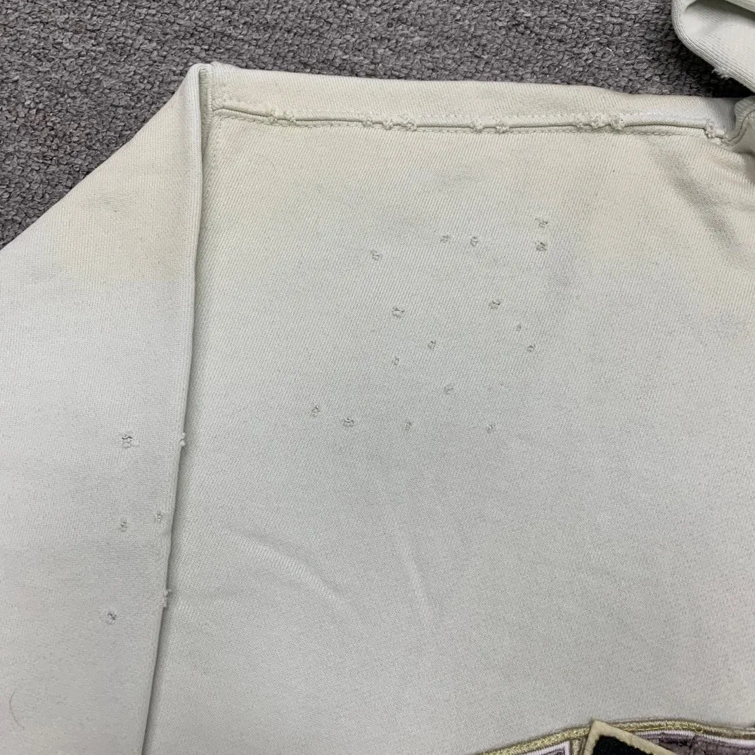 Additional details————Top-level verified version 23FW BALENCIAGA Paris Manchester United limited edition distressed male and female couple star same style pure cotton loose hooded sweatshirt [very suitable for Douyin, and other platforms! The letters in the LOGO position have been damaged and polished! 】 The fabric is custom-made washed knitted cotton terry material. The upper body is very soft. The front panel uses a classic hand pocket with a worn effect. The overall yellow and dirty effect is all artificially sprayed with majolica. It requires proficiency and experience to achieve this natural and elegant effect!  Customized towel embroidery on the chest, heavily damaged! The aging effect is very obvious! The overall artificial positioning coating is hand-made, washed and dirty. The frayed hole craftsmanship has a hand-painted graffiti effect. The arms behind the bend are made of open-stitch frayed craftsmanship. The wiring is delicate. Elastic cuff design. The whole body is hand-positioned with muddy dyeing and frayed effect! Ready-made garments are washed twice with water +➕ once with wax. It feels smooth!   The Manchester United letters and logo on the chest are designed with full embroidery and the details are visible!  Size: XS-L Color: White Black P: 470