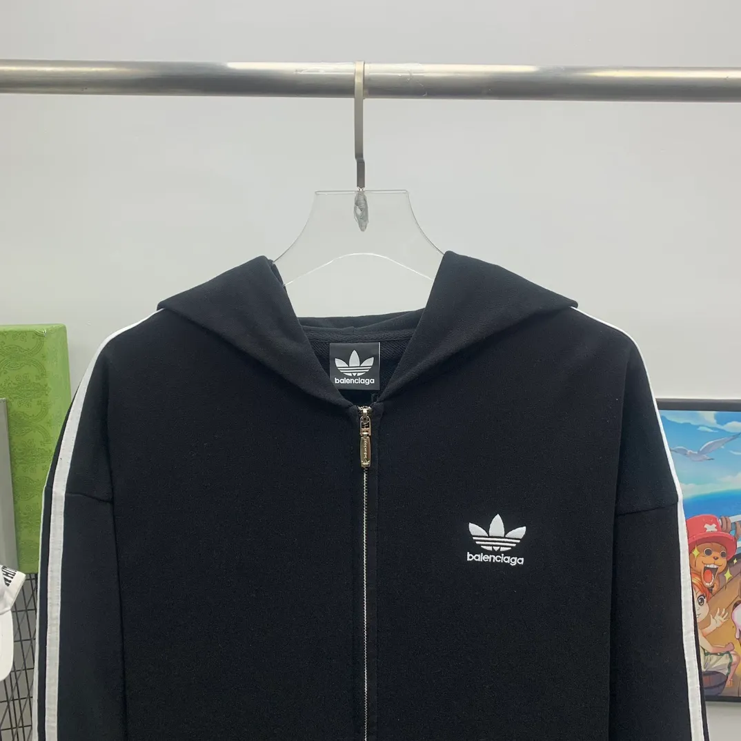 The top tested version of BALENCIAGA/Paris co-branded Adidas three-leaf clover LOGO embroidered hooded sweatshirt. The fabric is made of Paris ZP custom-woven and dyed cotton terry fabric. Weighing 450 grams, the cloth surface is clean. The cloth pattern is clear, soft and comfortable. The threads are dyed with no color difference. The classic pattern embroidery uses imported embroidery, and the letters are clear, three-dimensional and without rough edges. Custom-woven two-way zipper hardware, the upper zipper is BALENCIAGA, the lower zipper is Adidas, with electroplating effect! The sense of high-end is straight away! Comparisons welcome. The version adopts OS loose shoulder design. Same style for men and women. Color: Black Size: XS-L P:410