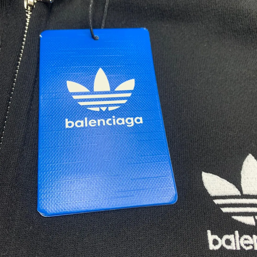 The top tested version of BALENCIAGA/Paris co-branded Adidas three-leaf clover LOGO embroidered hooded sweatshirt. The fabric is made of Paris ZP custom-woven and dyed cotton terry fabric. Weighing 450 grams, the cloth surface is clean. The cloth pattern is clear, soft and comfortable. The threads are dyed with no color difference. The classic pattern embroidery uses imported embroidery, and the letters are clear, three-dimensional and without rough edges. Custom-woven two-way zipper hardware, the upper zipper is BALENCIAGA, the lower zipper is Adidas, with electroplating effect! The sense of high-end is straight away! Comparisons welcome. The version adopts OS loose shoulder design. Same style for men and women. Color: Black Size: XS-L P:410