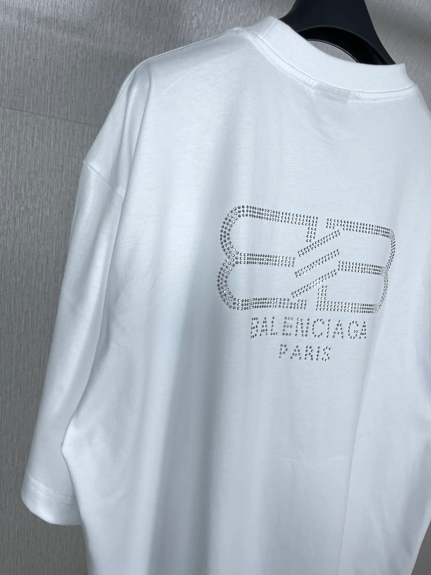 🅿️180 real photos [Top version. Official website quality] BALENCI*GA/Paris BALENCI*GA#23SS Paris classic lock button back classic LOGO hot-drilled short-sleeved T-shirt. Brick cabinet synchronization. The fabric is made of Paris ZP custom-woven and dyed 100% cotton double yarn compact cotton. The weight is 260 grams. The cloth surface is clean. The cloth pattern is clear. Soft and comfortable. Good color fastness. Not easy to change color. The threads are woven and dyed with no color difference. The back hot drill uses imported drill, which has good gloss and is not easy to fall off. Restore brick cabinet. The version adopts OS loose shoulder style. Same style for men and women. Code: BL223200 Color: Black. White Size: XS to L
