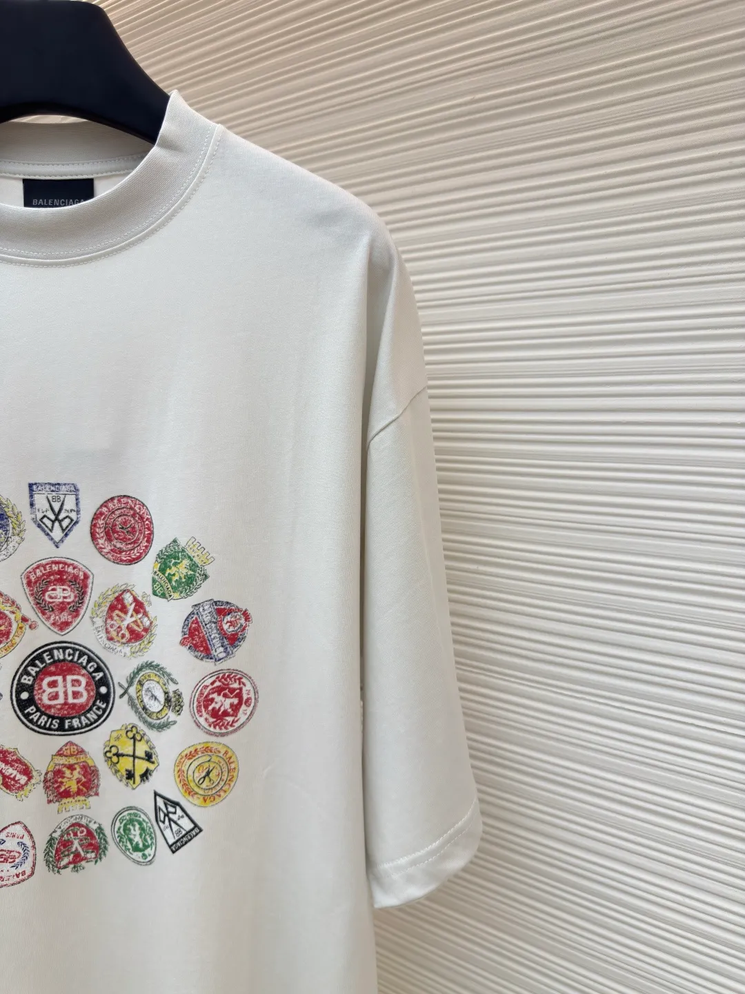 Balenciaga collection of trademark printed round neck short sleeves ●Original version: Purchased and developed at 3730 ●Item number: 1680781-A10 ●Fabric: Retro jersey fabric ●Technology: Glue printing ●Version: Loose version ●Weight: about 235 grams ●Size: Thread, 270g. 24S fabric is a medium-to-thick yarn, suitable for creating thick, crisp fabrics with a slightly rough texture, which is in line with the "natural and original" effect pursued by retro style. The texture is soft, breathable and elastic, suitable for close-fitting wear and able to create a simple and smooth silhouette. The loose silhouette design details with a retro feel are reflected through old textures, faded processing, and classic tailoring. Dark floral dot multi-layer overlay printing is an advanced printing technology that combines fine patterns and three-dimensional layers. Its core is to use high-mesh dot plate making to overprint transparent or light-colored printing paste on the fabric base multiple times with micron-level precision. Each overlay is accurately aligned to form a faint dark flower texture. The printing pattern does not rely on bright colors, but creates subtle light and shadow gradients and tactile layering on the surface of the fabric through the thickness difference of slurry accumulation and light refraction. The pattern shows subtle changes at different angles, combining visual depth and long-lasting washability. Oversize loose silhouette design, basic round neckline, dropped shoulder line, vertical pit woven code from top to bottom, collar, cuffs, and hem all have ruffles, and the sleeve length is longer to highlight the details. The thickness of the ready-made garment is the same as the original version, and it is additionally shaped to make the upper body wider and not easily deformed. The overall wiring is straight and delicate, the fabric is comfortable and soft, and the color is consistent without color difference. It can be matched with the same style to create a fashionable look and control various occasions. Customized accessories, complete with three standards, same style for men and women!