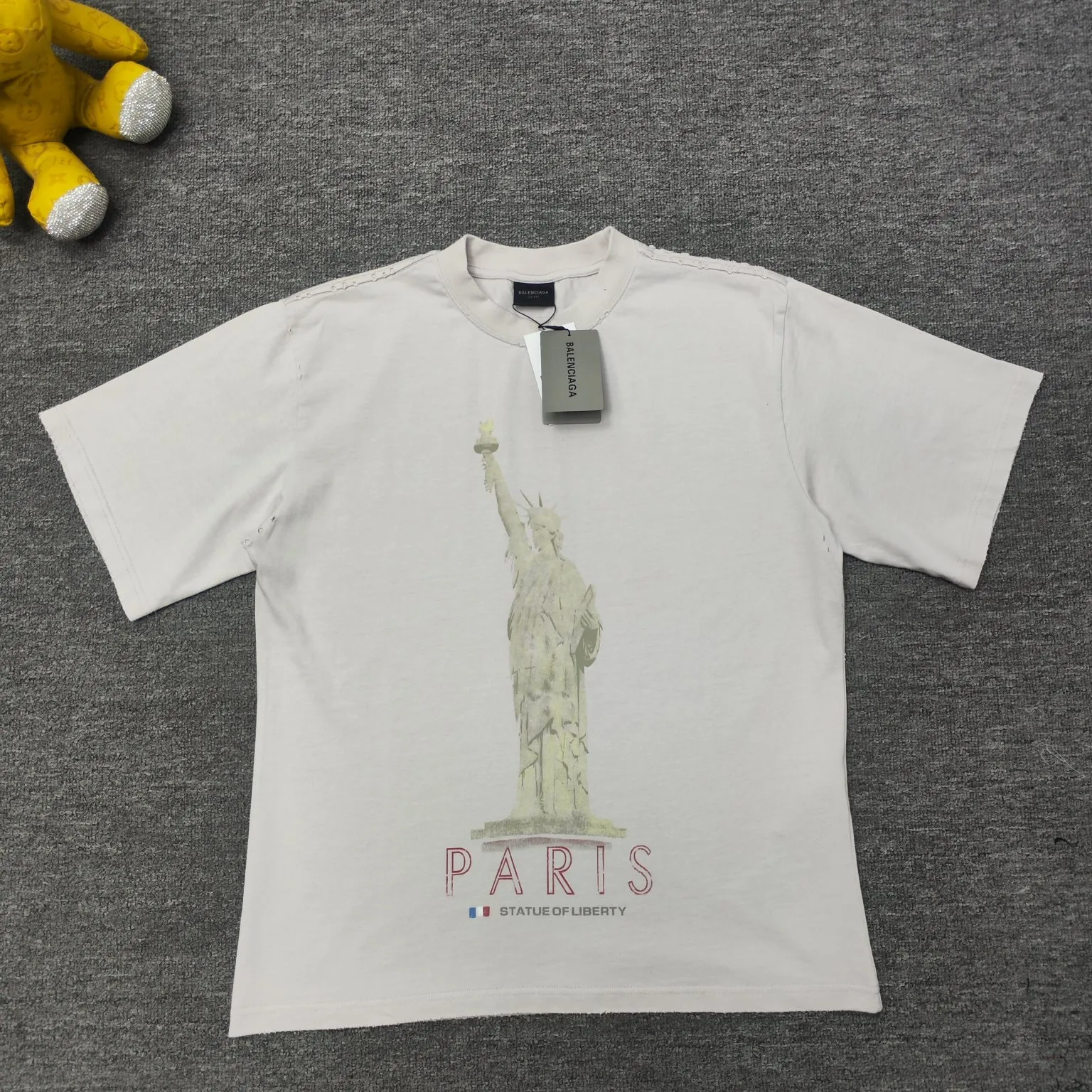 [New] Top version - BALENCIAGA - Statue of Liberty printed short-sleeved T-shirt. The original development of custom-woven fabric technology and washing treatment. High-gram weight 300-gram fabric, full texture, clean cloth surface, soft and comfortable. Solona thread dyeing has no color difference. The fabric uses a plain weave structure made of thicker yarns and has a retro style. Plain weave is a basic fabric structure characterized by frequent interweaving of warp and weft yarns. The fabric has a smooth appearance, clear texture, and a relatively light feel. Ready-to-wear garments are generally washable and comfortable to wear. The front is decorated with the Statue of Liberty. Printing process The Statue of Liberty National Monument, also known as Liberty Enlightening the World, is located on Liberty Island, New York, USA. On the occasion of the 100th anniversary of the founding of the United States, France presented a statue representing freedom. The underside of the statue is transformed into a Paris letter print, which is very symbolic. The design language of Balenciaga has a profound meaning. Graffiti prints are handsome and full of style. Washed and worn hole crafts os drop shoulders and loose version. Same style for men and women. Color: active white black. Size: XS-L P:300